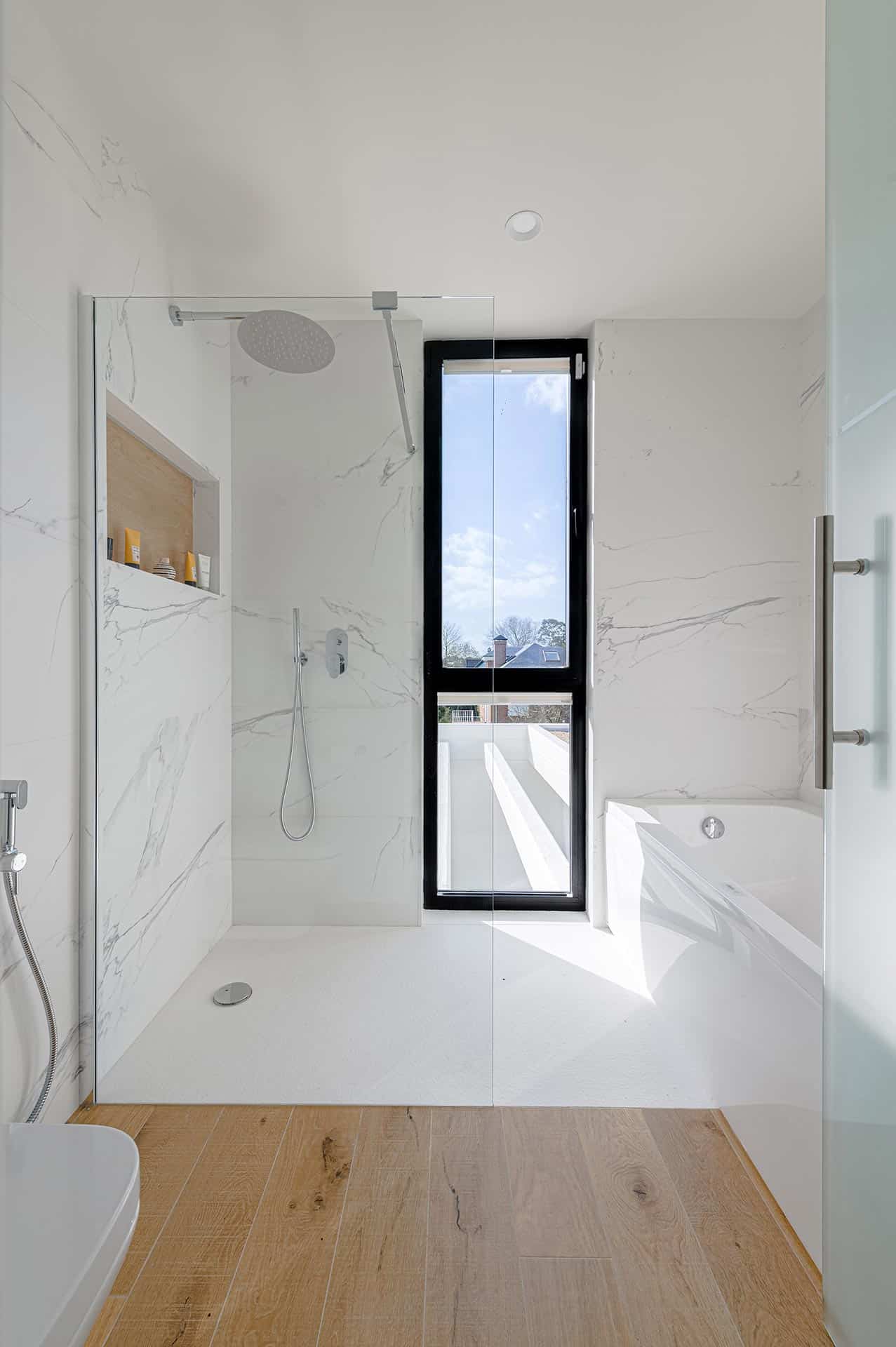 Baño de mármol blanco de casa moderana diseñada por Moah Arquitectos en Cantabria