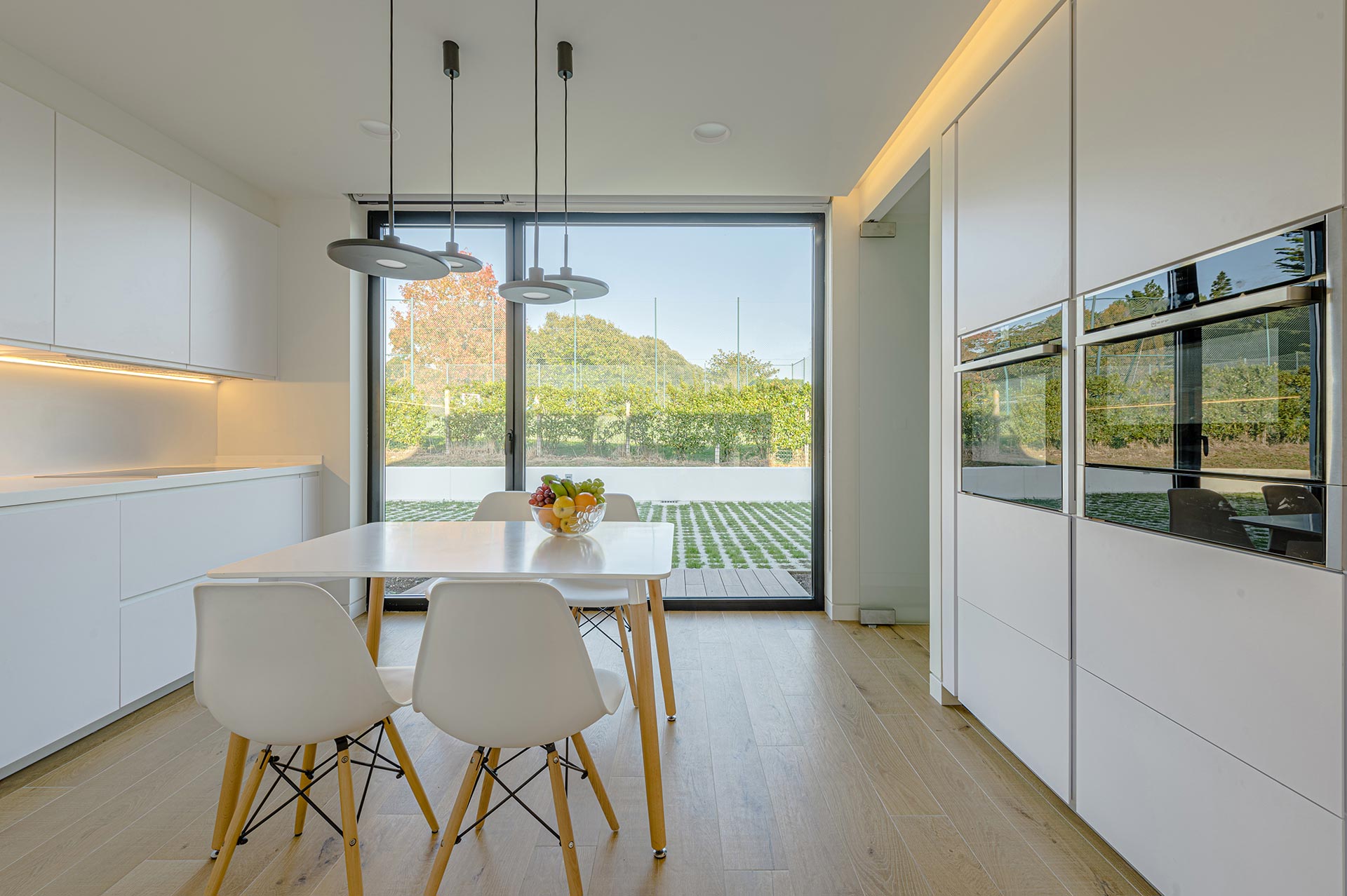 White kitchen with big windows designed by Moah Interior Designers in Cantabria