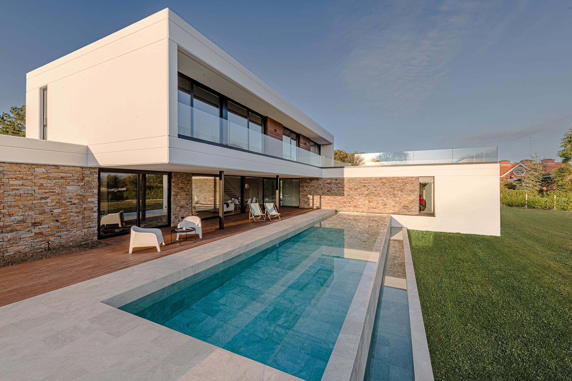 Vivienda de diseño con fachada de hormigón y piscina cerámica diseñada por Moah Arquitectos en Loredo