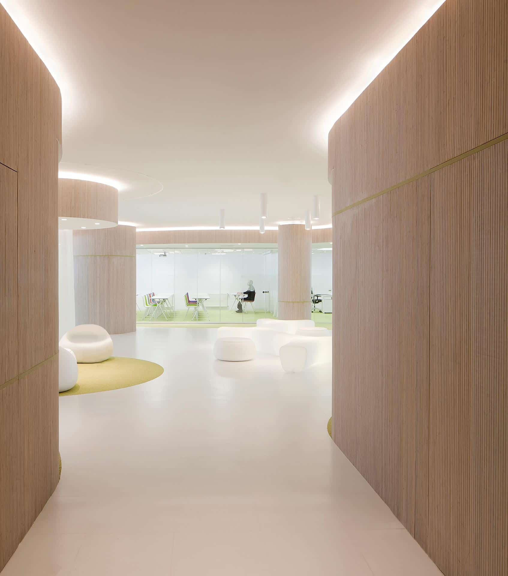 Suelo blanco y paredes de madera de la reforma de oficina del CISE diseñado por Moah Arquitectos en Cantabria