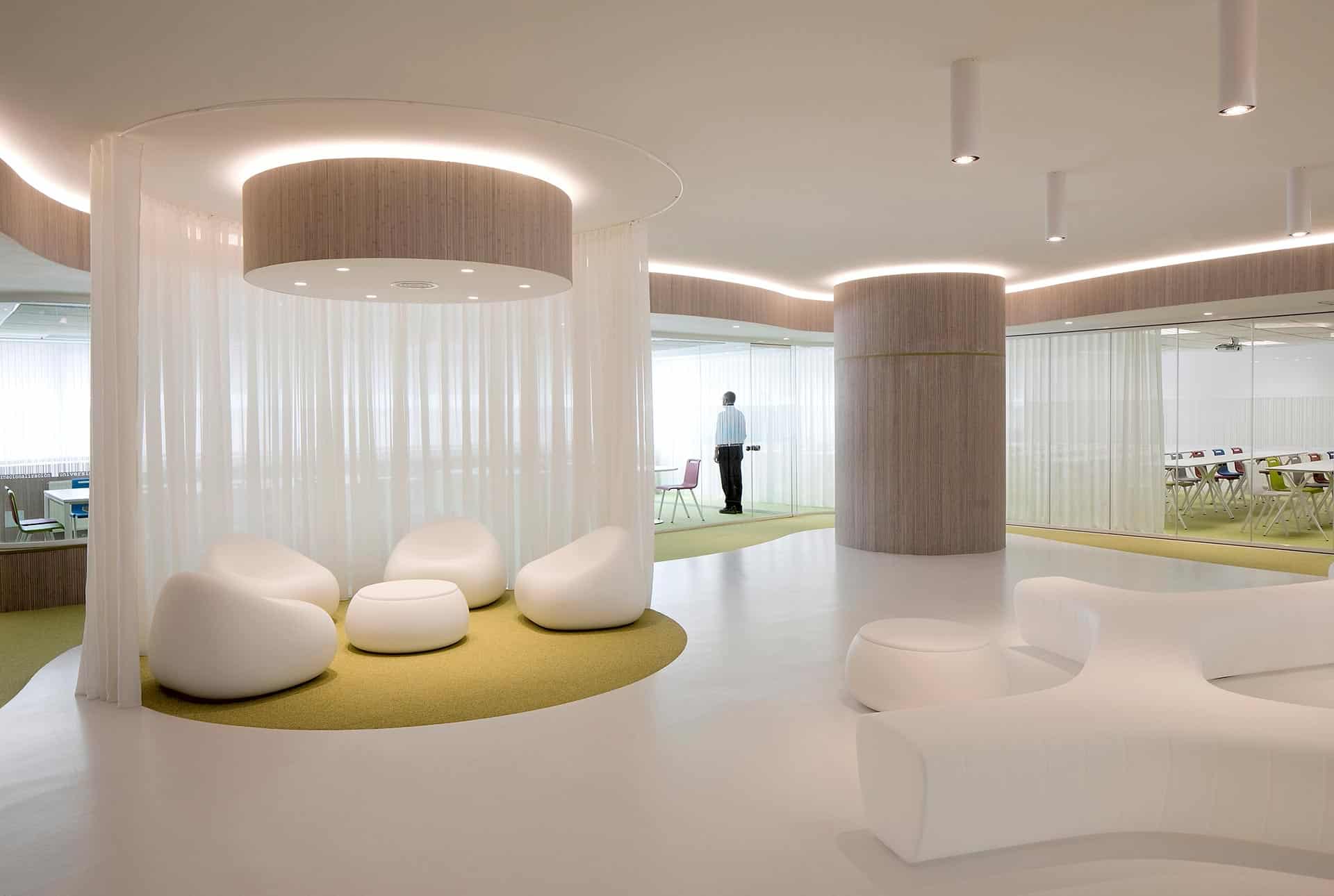 Vestíbulo con suelo blanco y cortinas translucidas en oficinas modernas del CISE diseñadas por Moah Arquitectos en Santander
