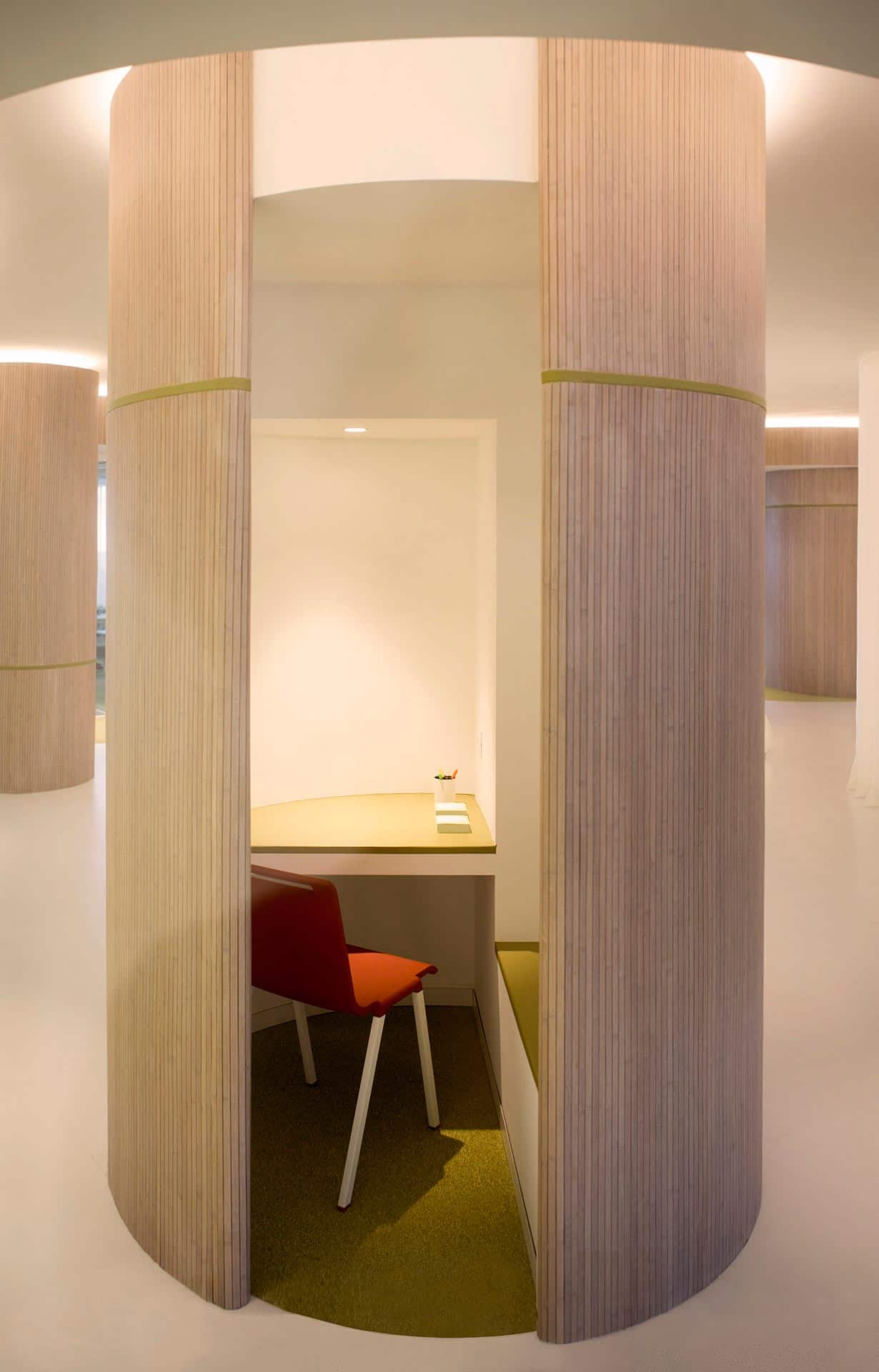 Gradas de madera y suelo verde en reforma de oficina del CISE diseñado por Moah Arquitectos en Santander