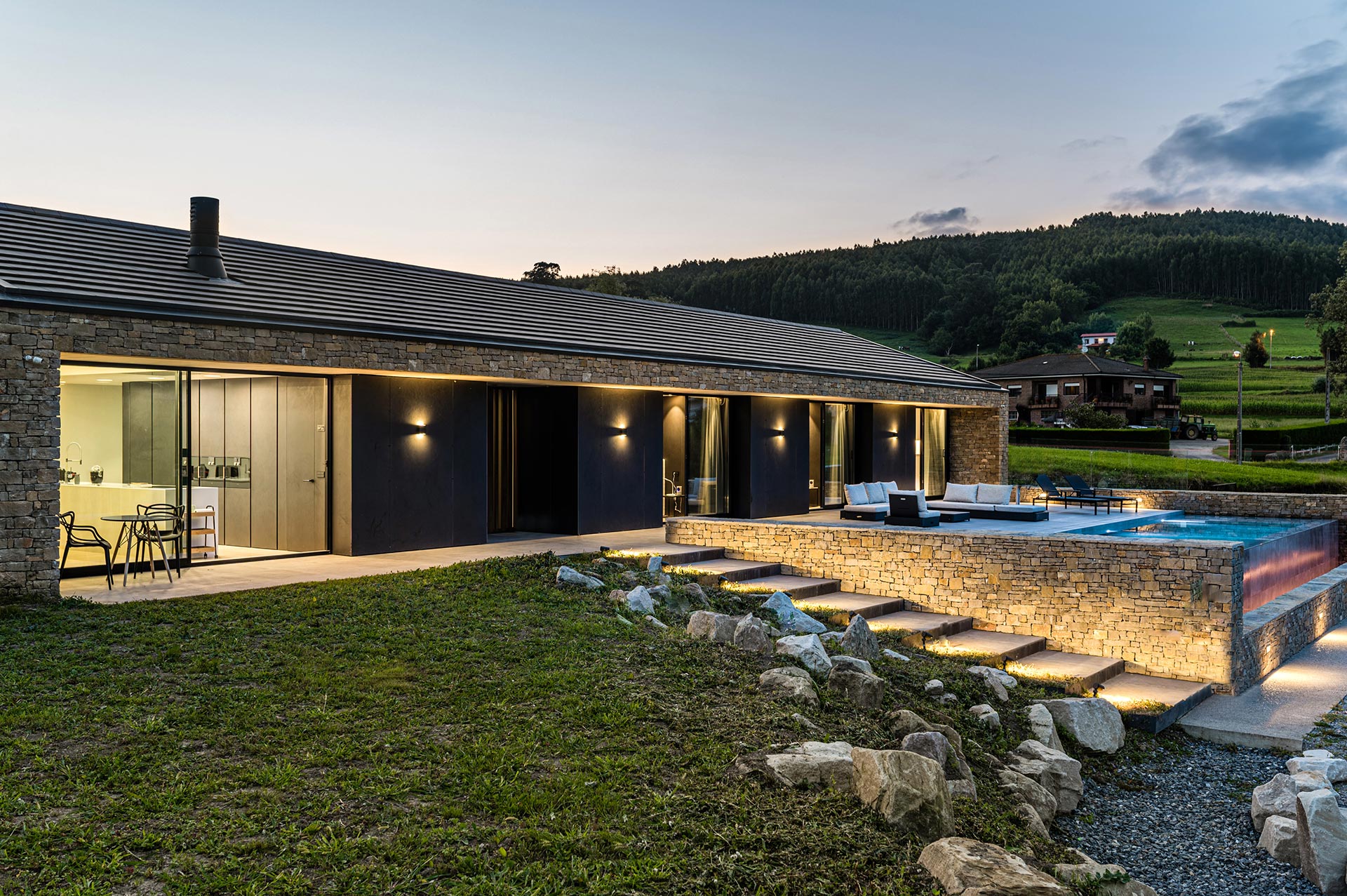 Casa moderna de piedra con piscina diseñada por Moah Arquitectos en Güemes