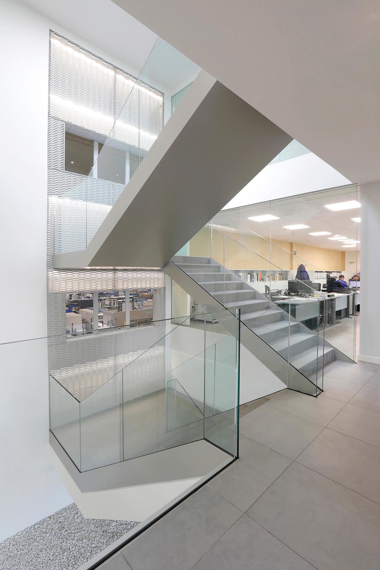 Escalera en triple altura en reforma de oficina de diseño diseñada por Moah Diseñadores de Interiores en Cantabria