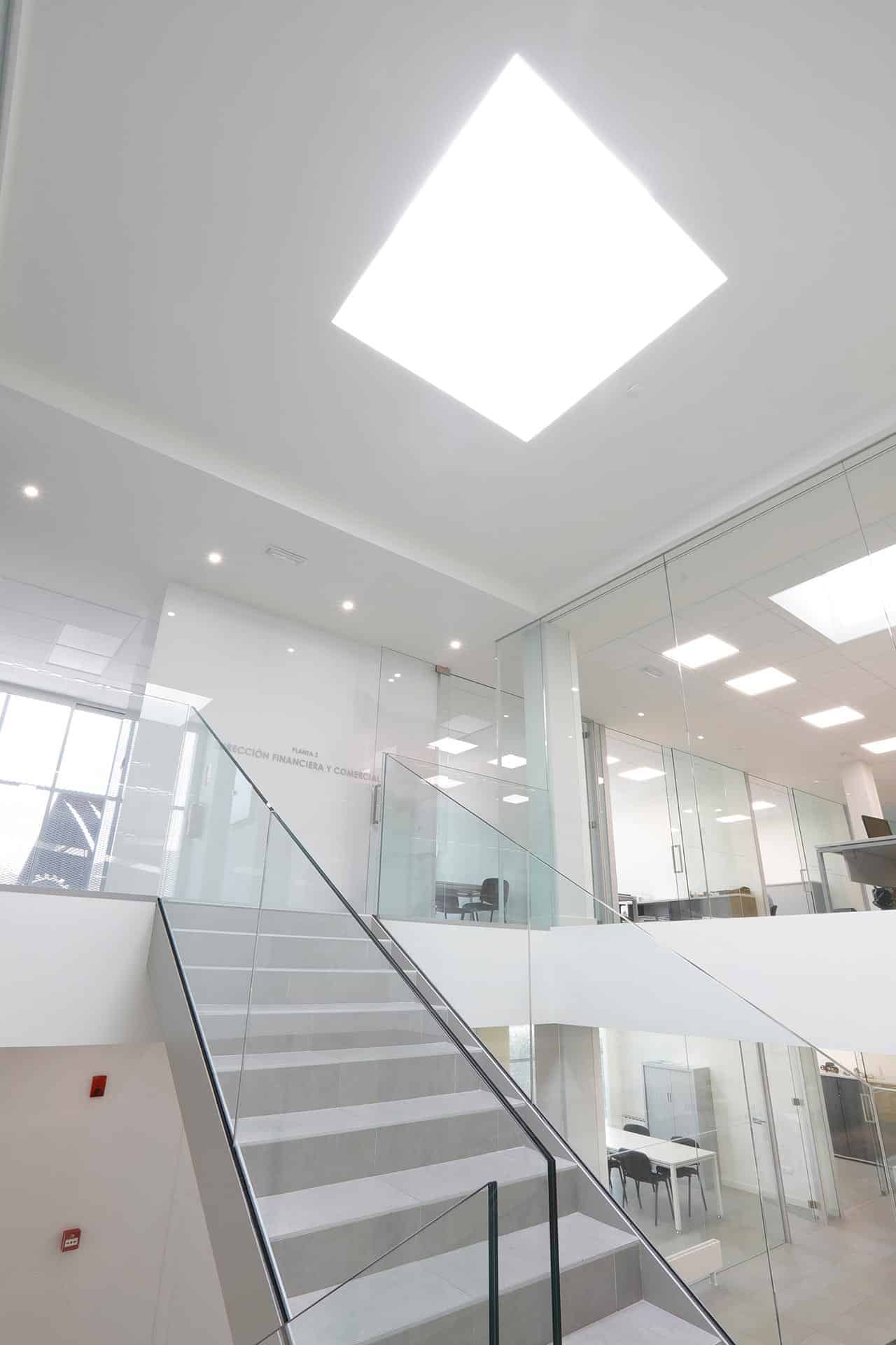 Escalera con lucernario y grandes cristaleras en reforma de oficina de diseño diseñada por Moah Diseñadores de Interiores en Cantabria