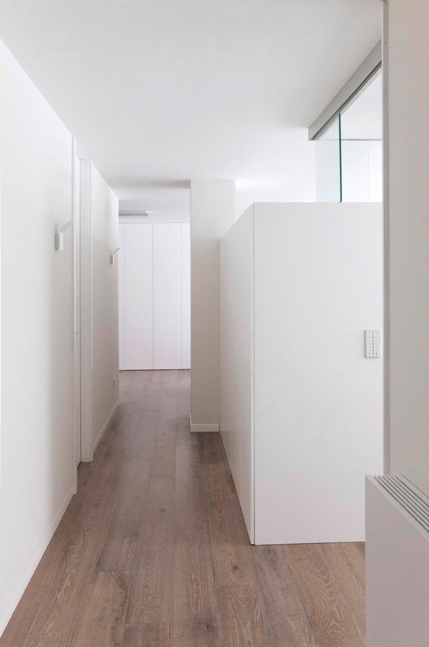 Pasillo blanco de diseño en reforma integral de vivienda diseñada por Moah Diseñadores de Interiores en Santander