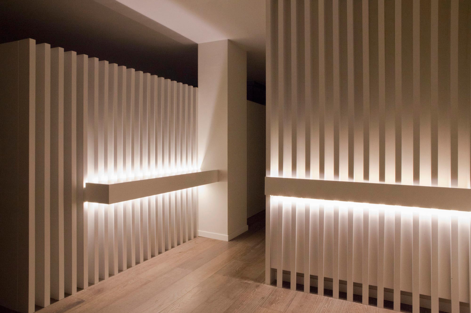 Lamas blancas con iluminación en reforma integral de vivienda de lujo diseñada por Moah Arquitectos en Santander