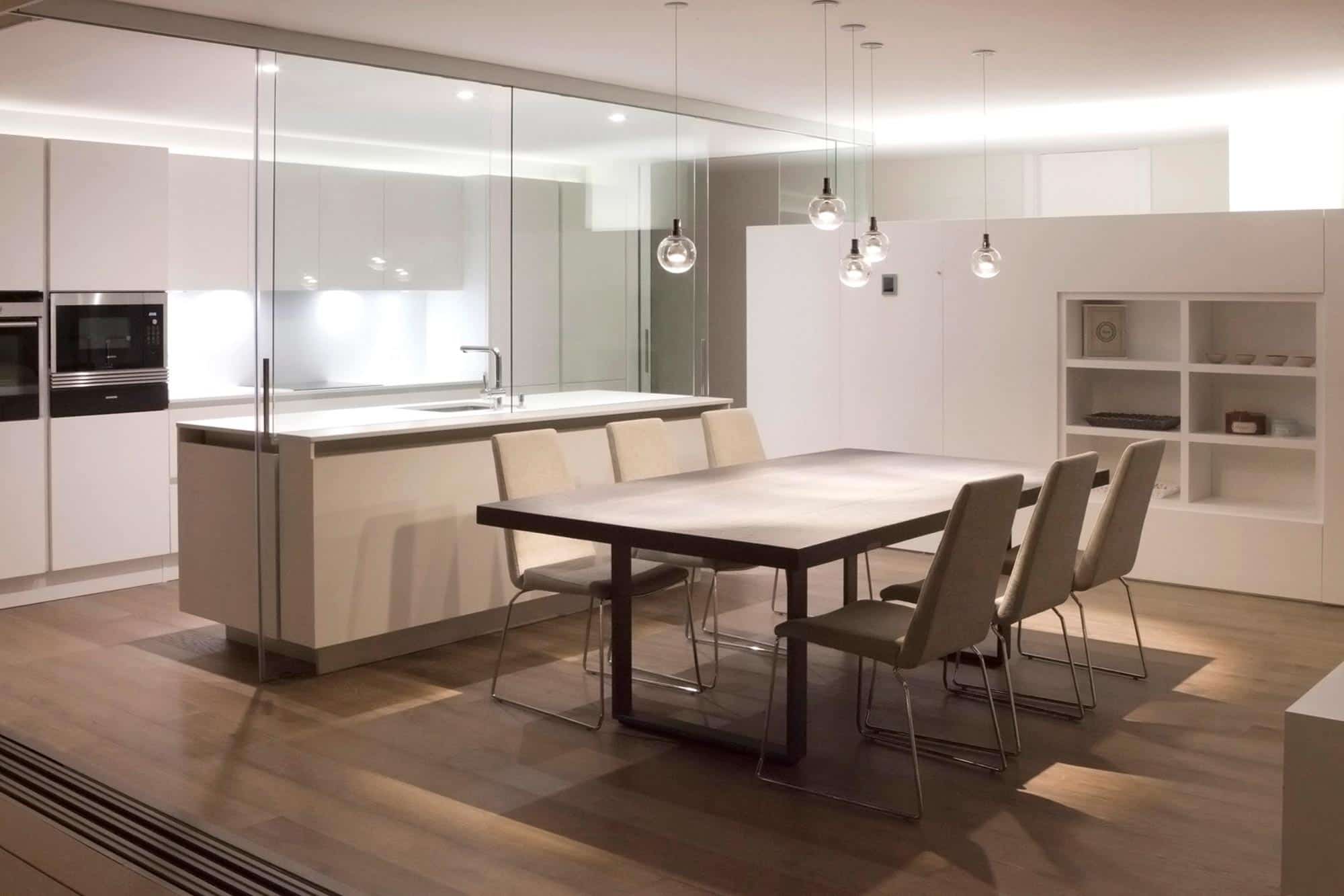 Cocina y comedor con iluminación indirecta en reforma integral de vivienda diseñada por Moah Diseñadores de Interiores en Santander