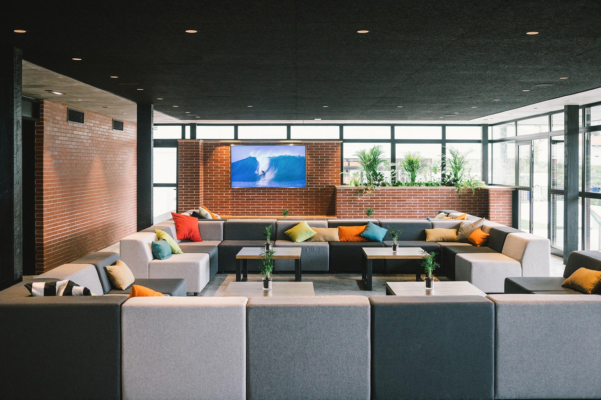 Salón con sofás de colores de albergue y hotel de diseño diseñado por Moah Arquitectos en Loredo