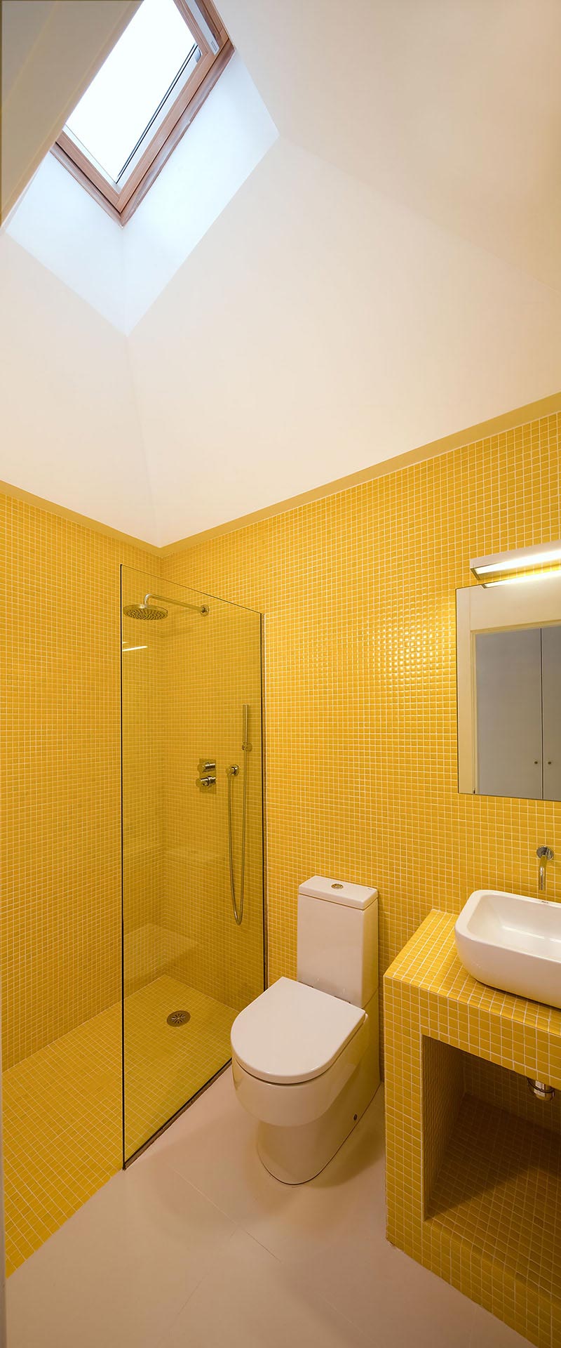 Baño con gresite amarillo de casa moderna diseñada por Moah Arquitectos en Villaverde