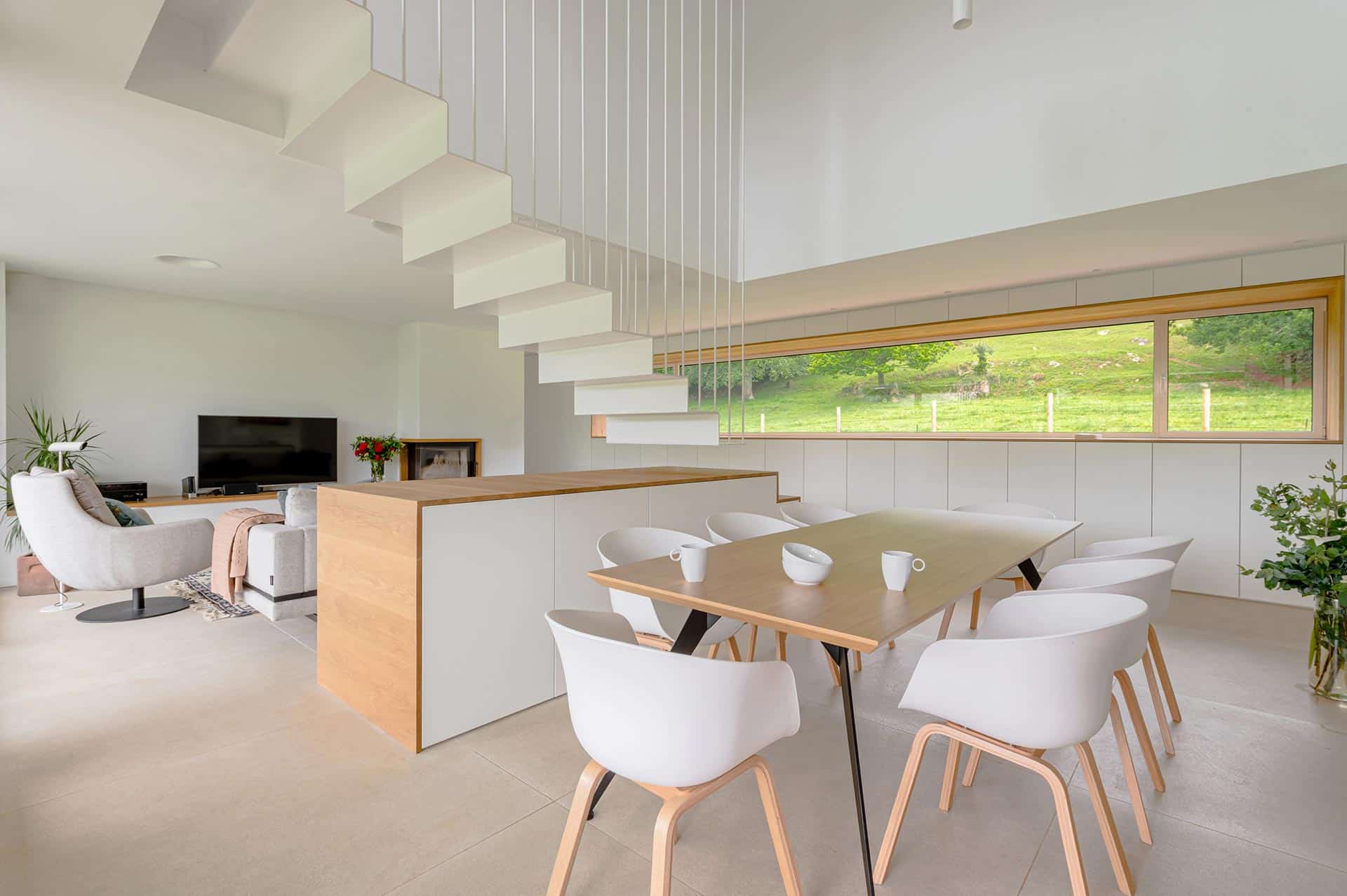 Comedor y escalera con tirantes de vivienda moderna de lujo diseñada por Moah Arquitectos en Pámanes