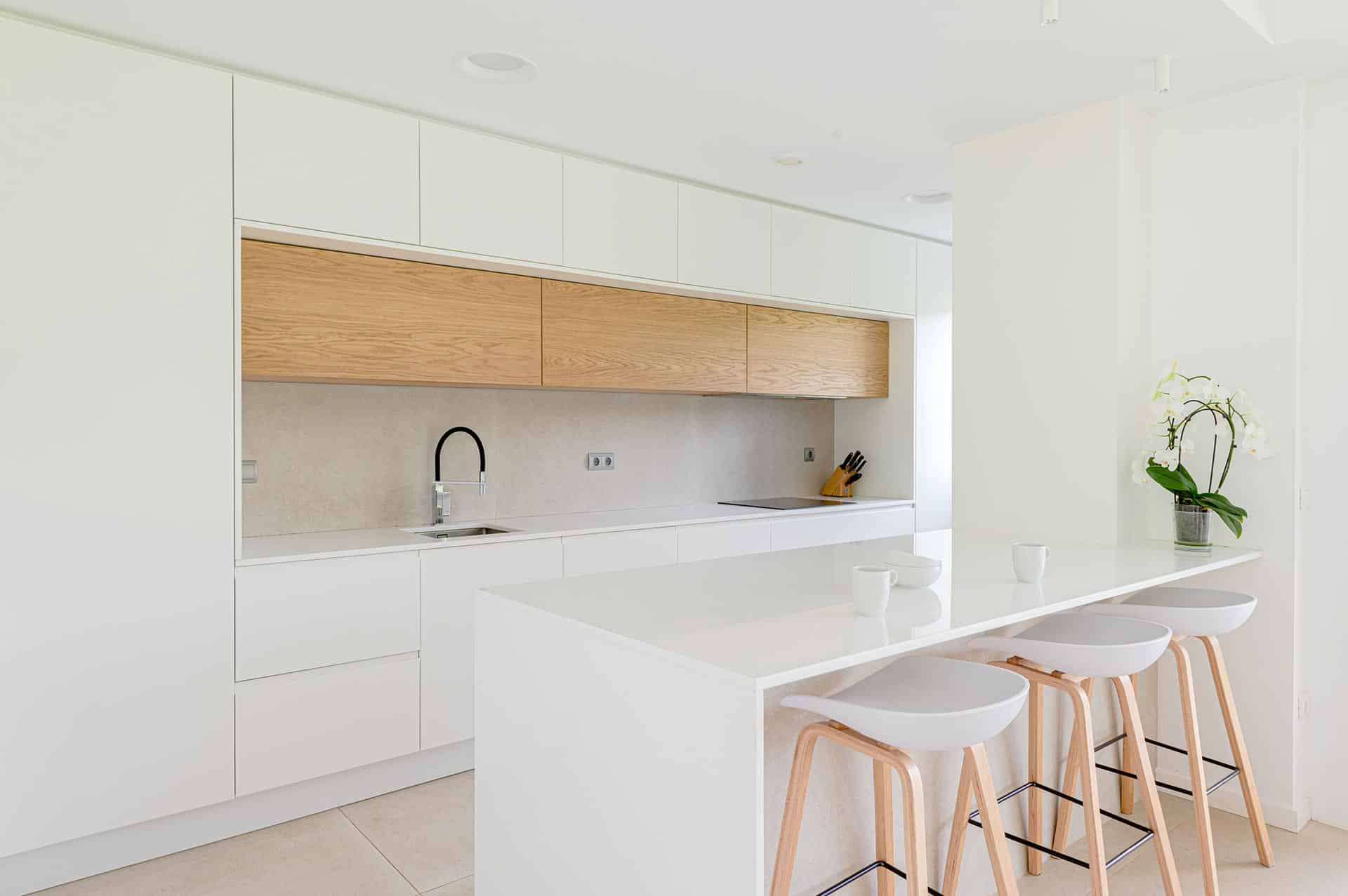 Isla de cocina blanca minimalista de vivienda moderna unifamiliar diseñada por Moah Arquitectos en Pámanes