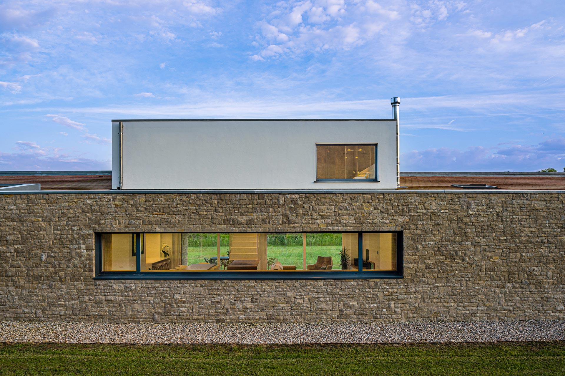 Fachada de piedra y mortero en casa moderna diseñada por Moah Arquitectos en Pámanes