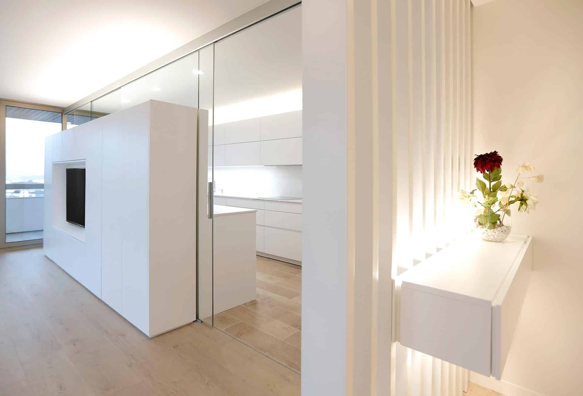 Vestíbulo y cocina en vivienda diseñada por Moah Arquitectos en Santander