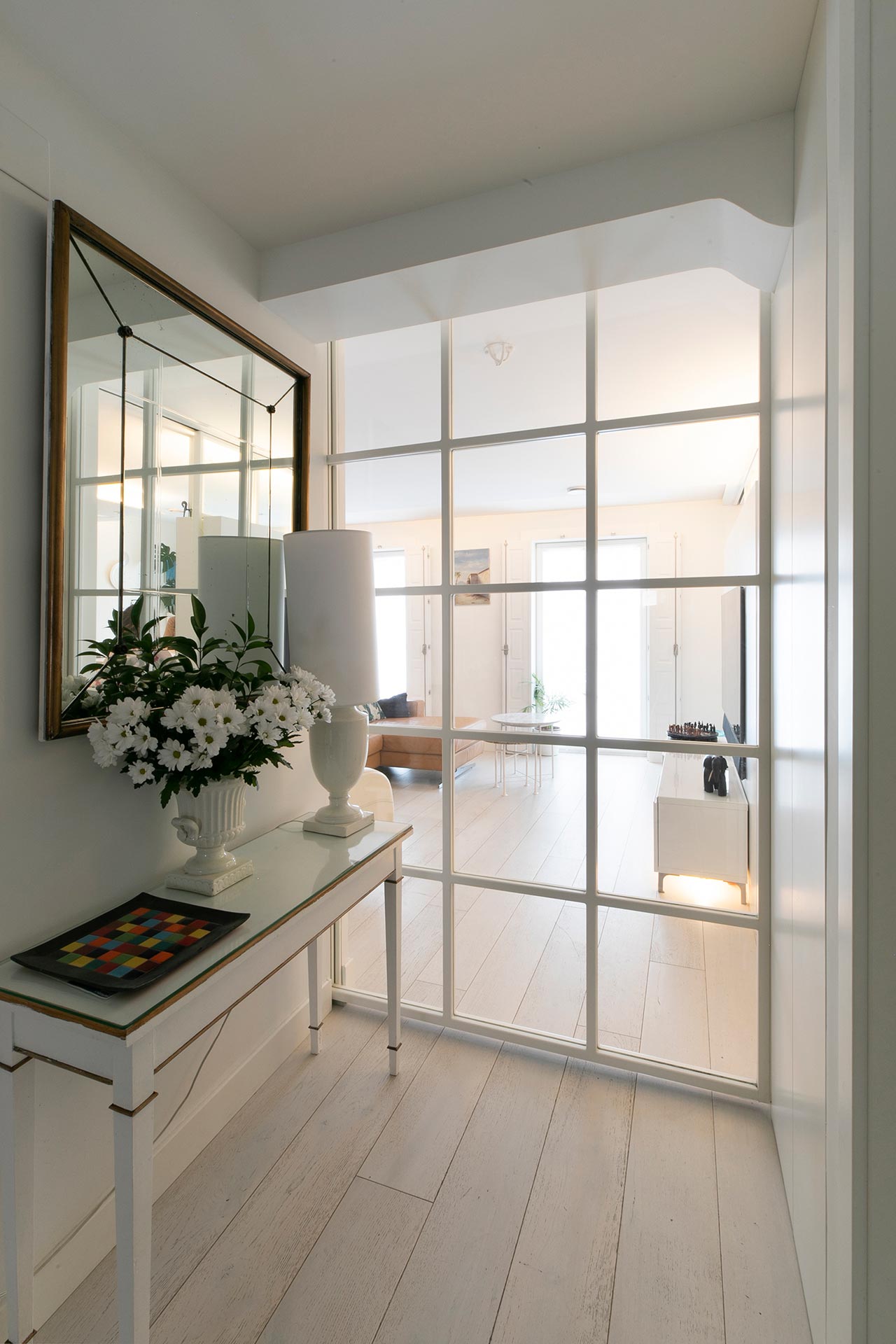 Recibidor con puertas de cristal en reforma de vivienda moderna diseñada por Moah Arquitectos en Santander