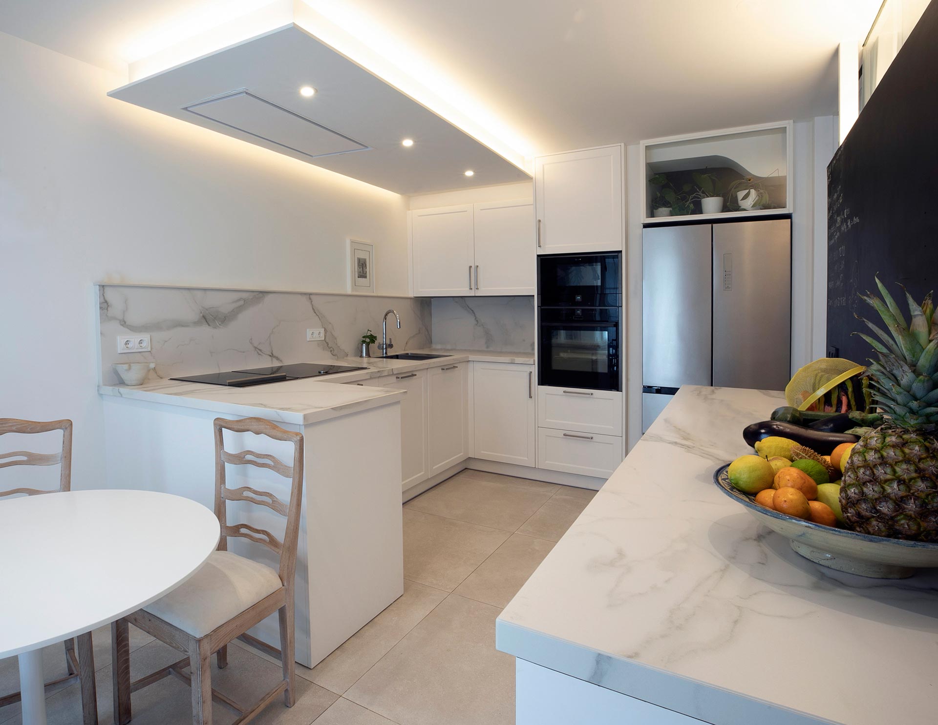 Cocina con iluminación indirecta en reforma de vivienda moderna diseñada por Moah Arquitectos en Santander