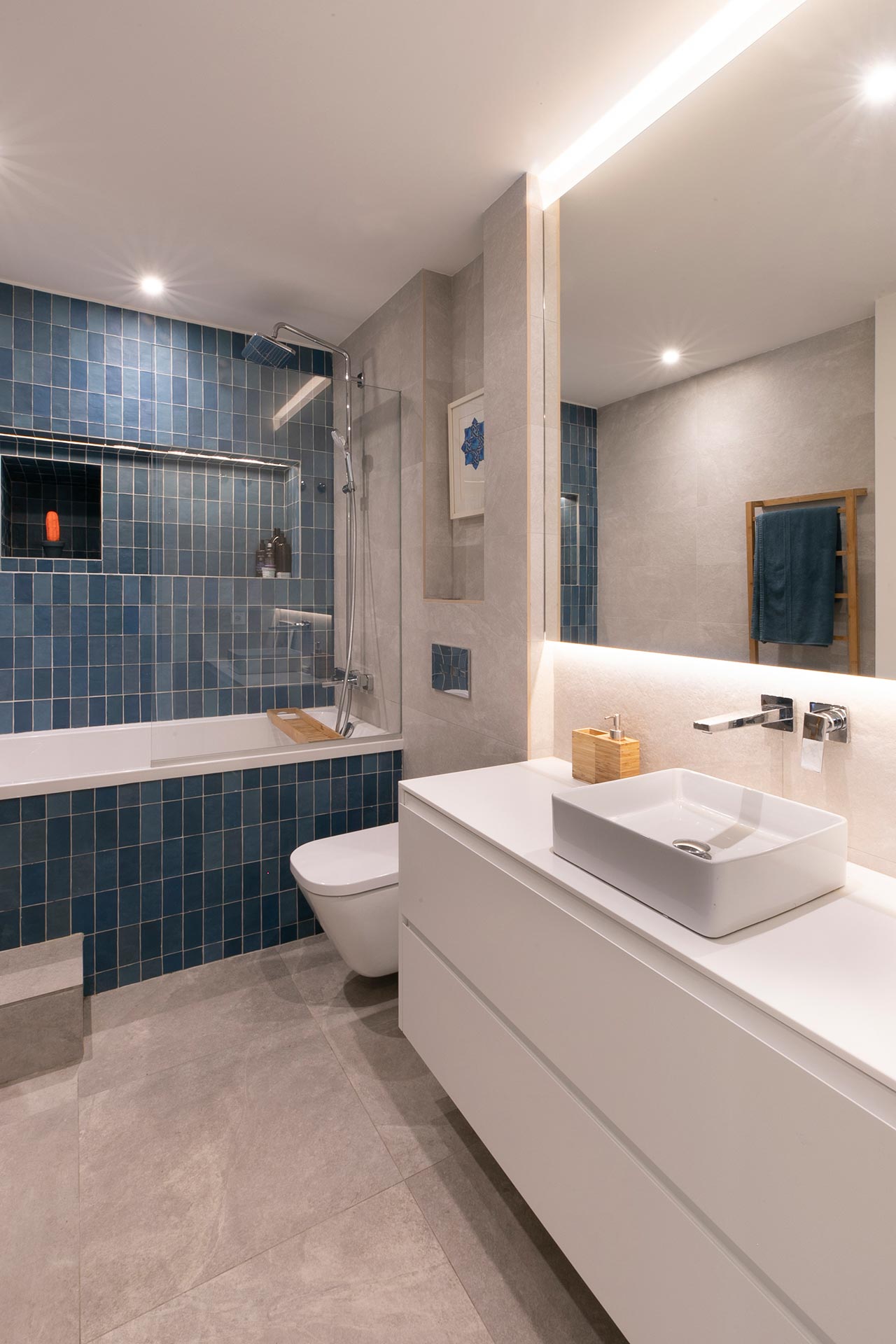 Baño con gres azul en reforma de vivienda moderna diseñada por Moah Arquitectos en Santander