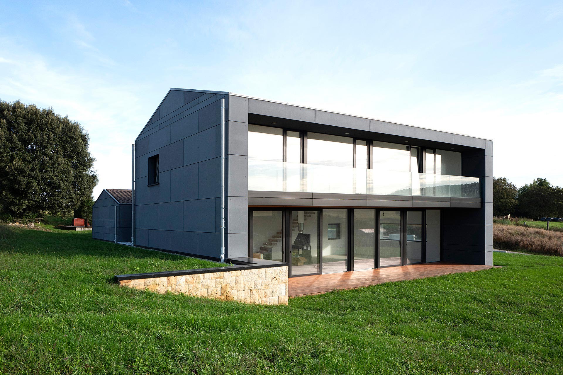 Casa moderna grandes ventanales y barandilla vidrio diseñada por Moah Arquitectos en Cantabria