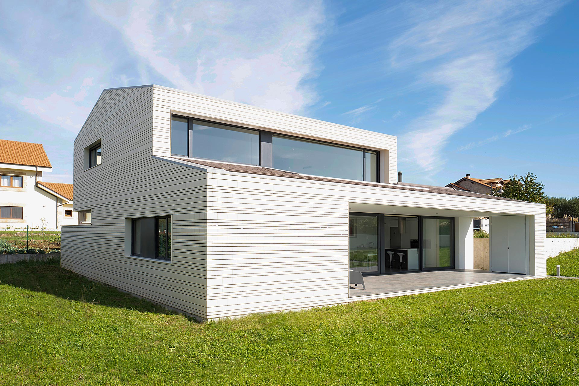 Fachada de ladrillo blanco en casa moderna diseñada por Moah Arquitectos en Villaverde, Cantabria