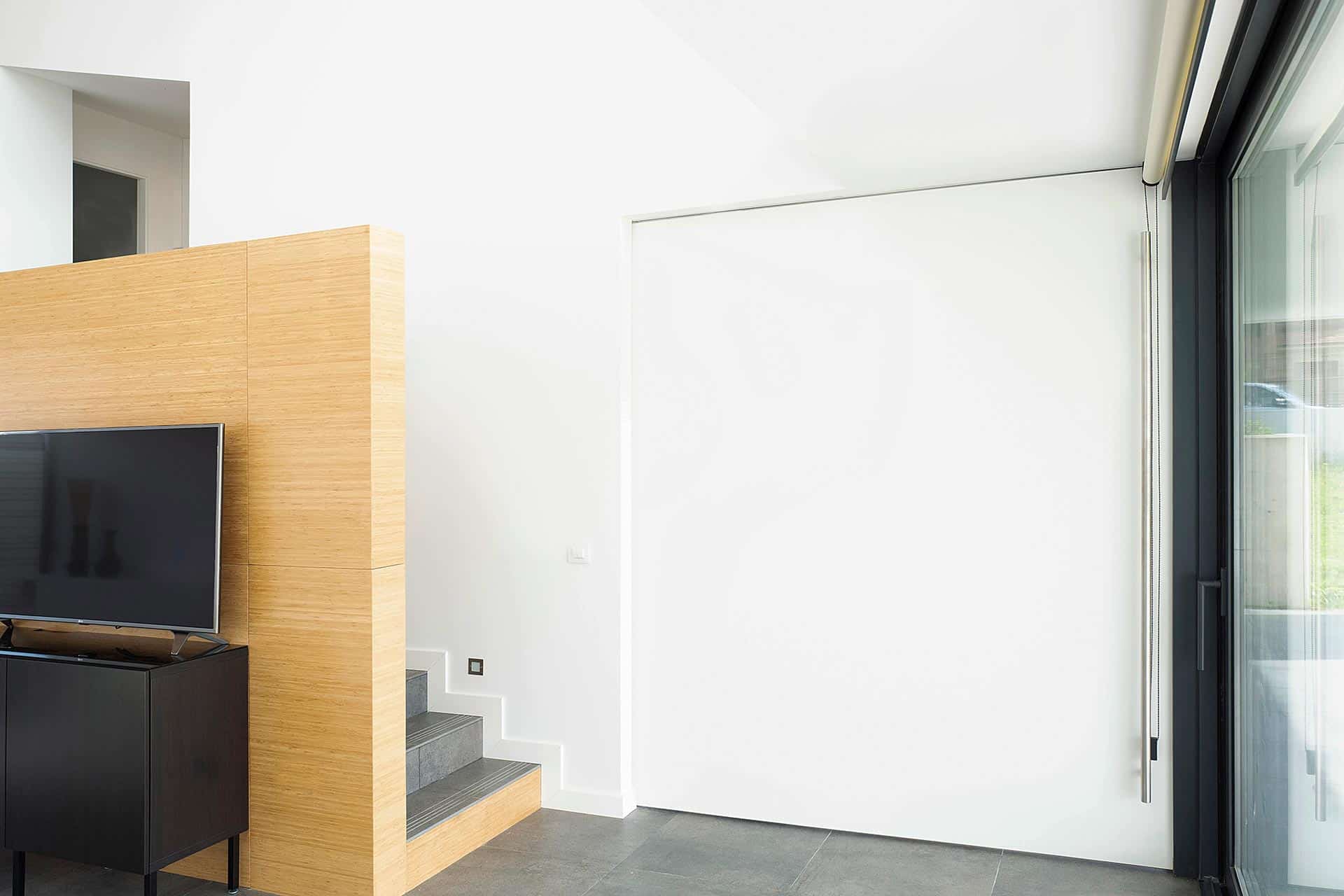 Portón corredero blanco en casa moderna diseñada por Moah Arquitectos en Villaverde, Cantabria