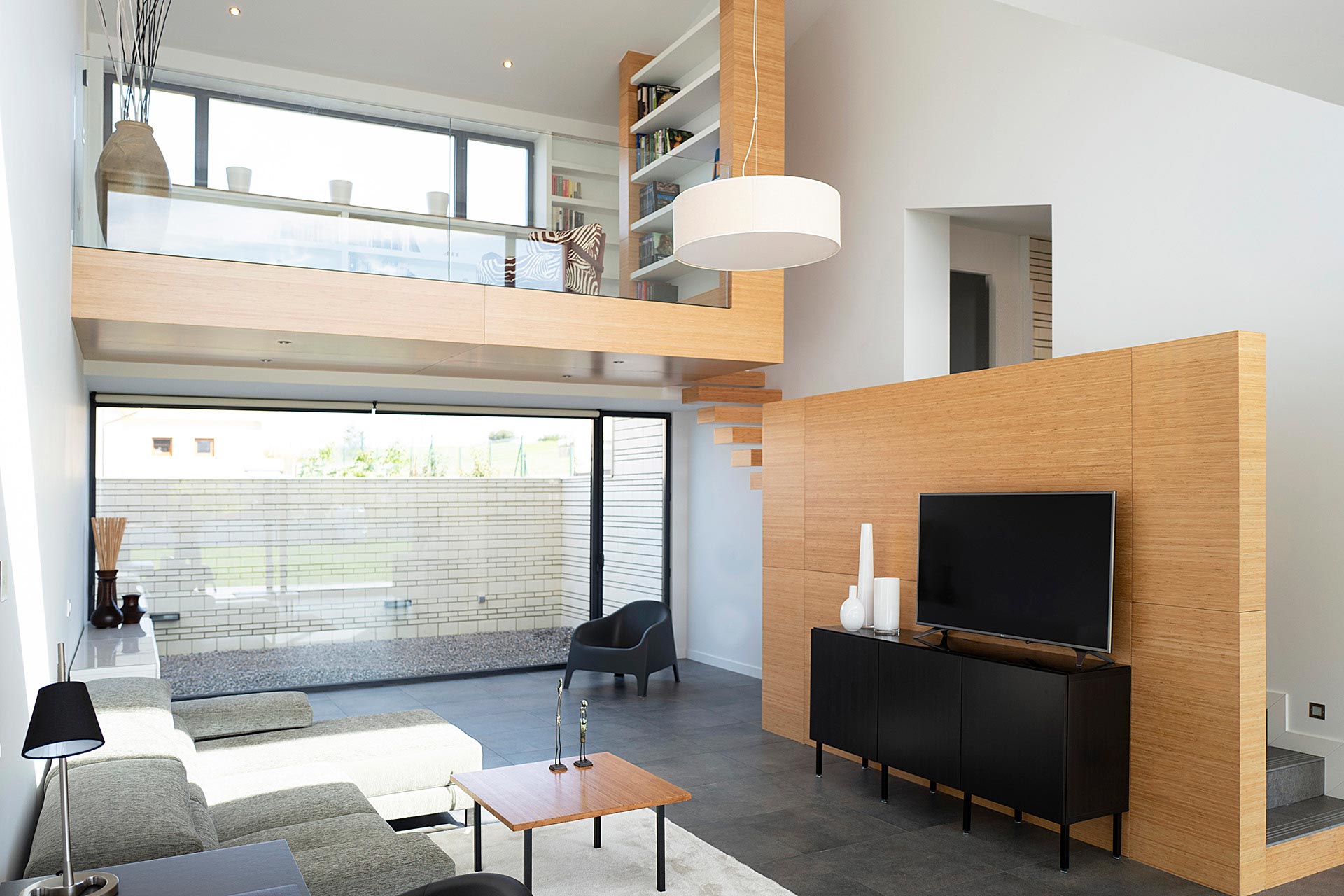 Salón en doble altura en casa moderna diseñada por Moah Arquitectos en Villaverde, Cantabria