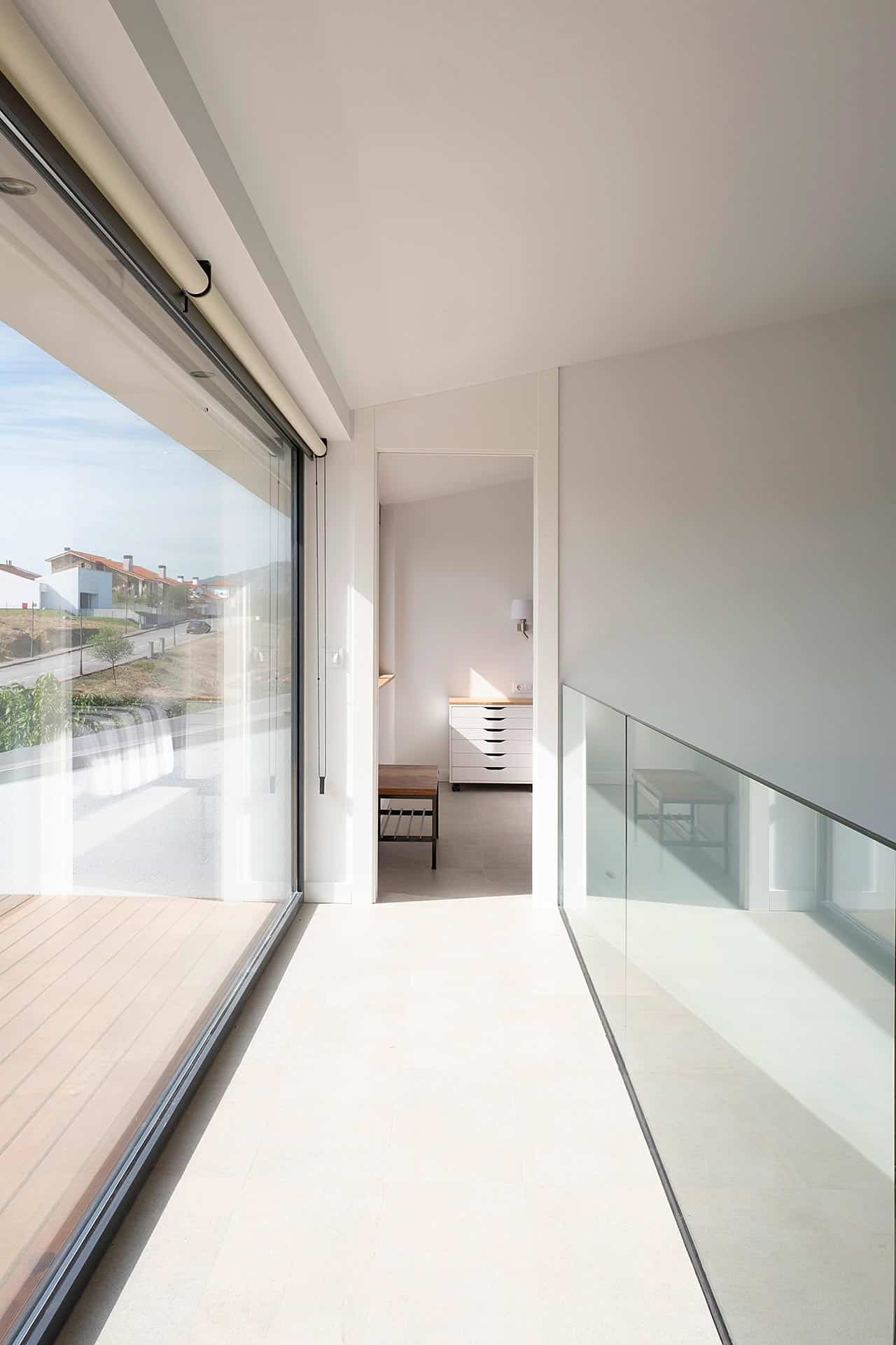 Interior minimalista en casa moderna en blanco y cristal diseñado por Moah Arquitectos en Cantabria