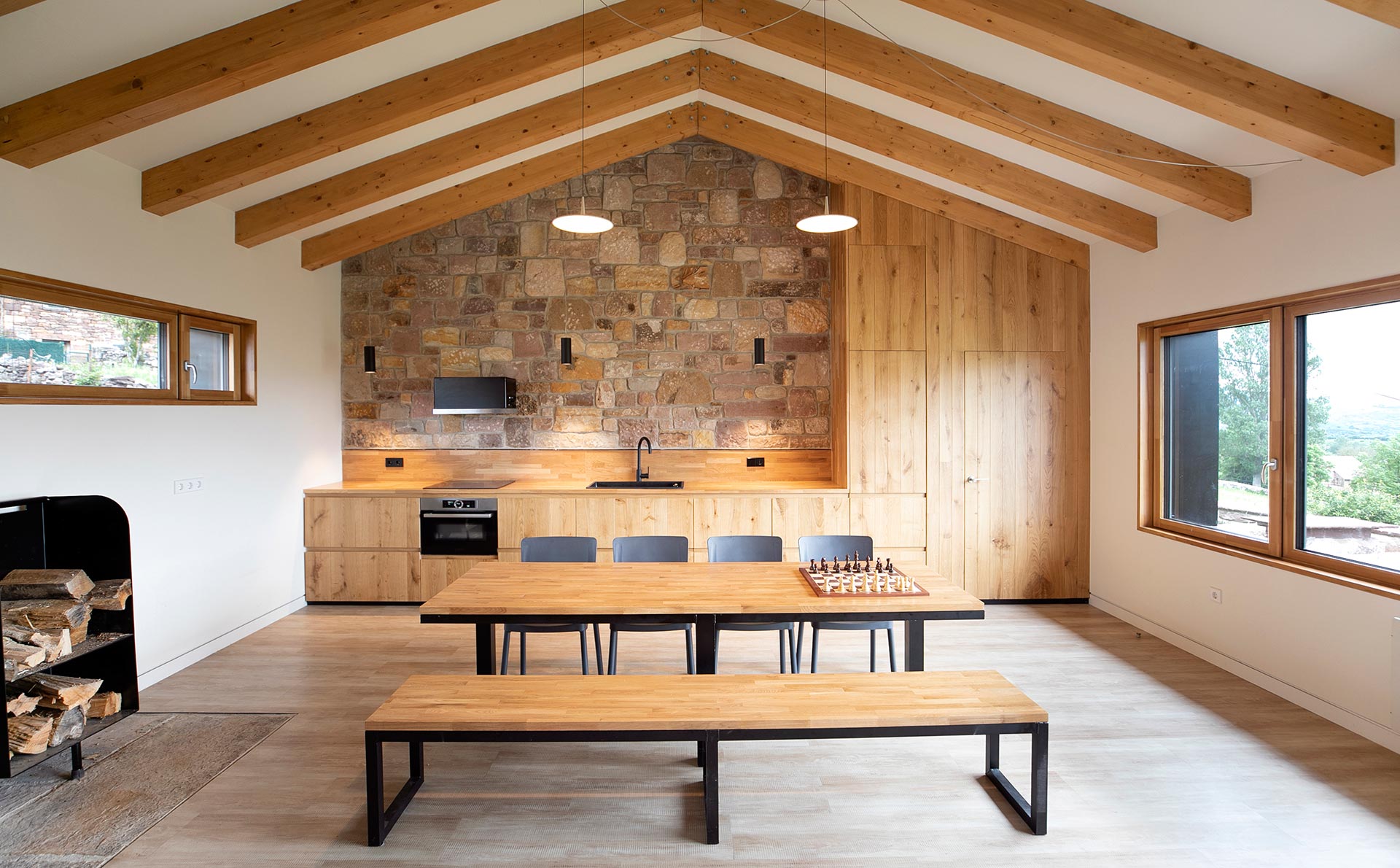Comedor y cocina de madera de cabaña pasiva en Proaño diseñada por Moah Arquitectos en Cantabria