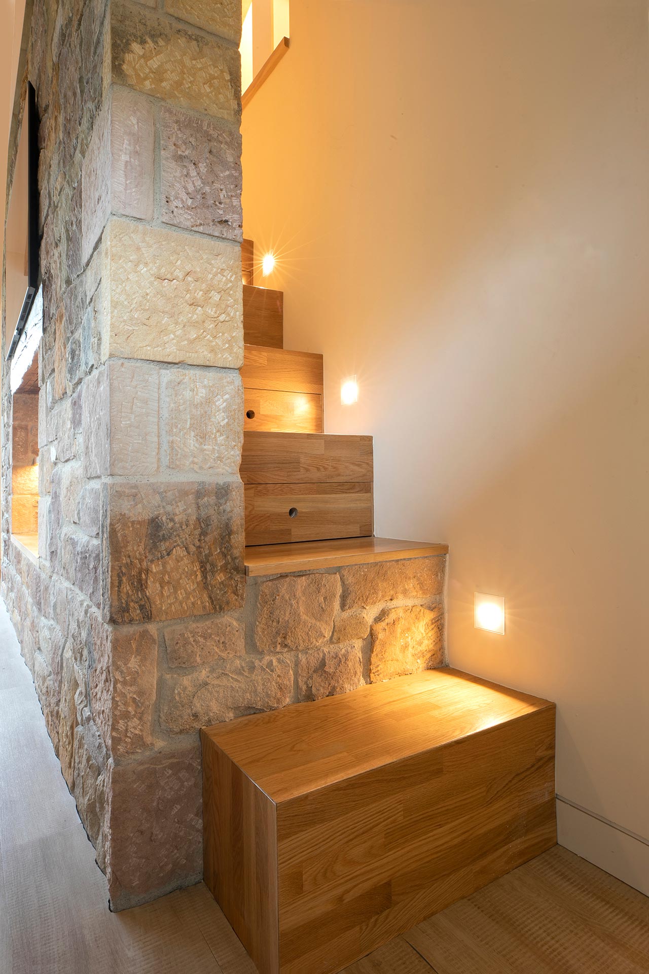 Escalera de madera y piedra de alojamiento moderno en Proaño diseñada por Moah Arquitectos en Cantabria