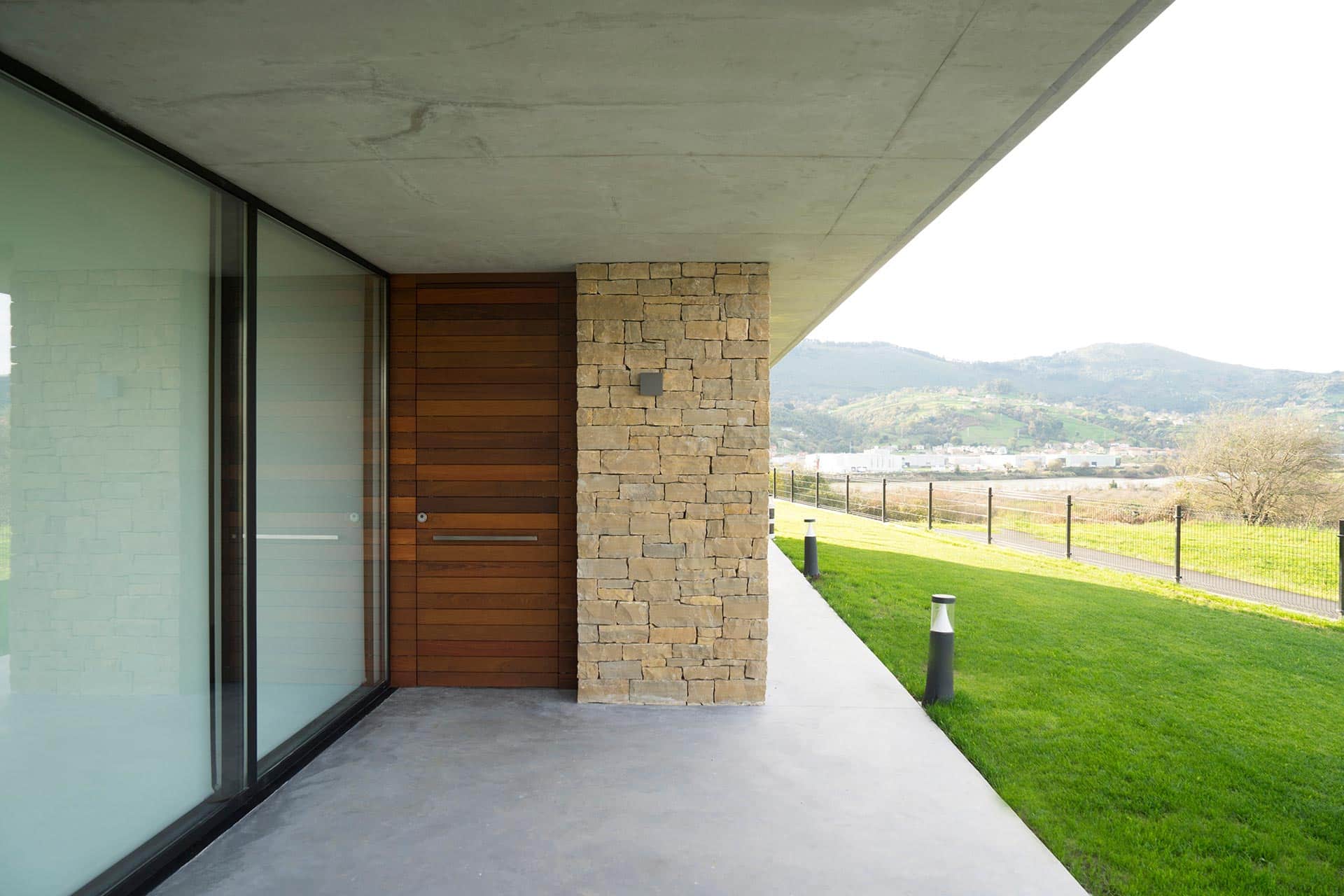 Puerta de madera exterior diseñado por Moah Arquitectos en Pontejos