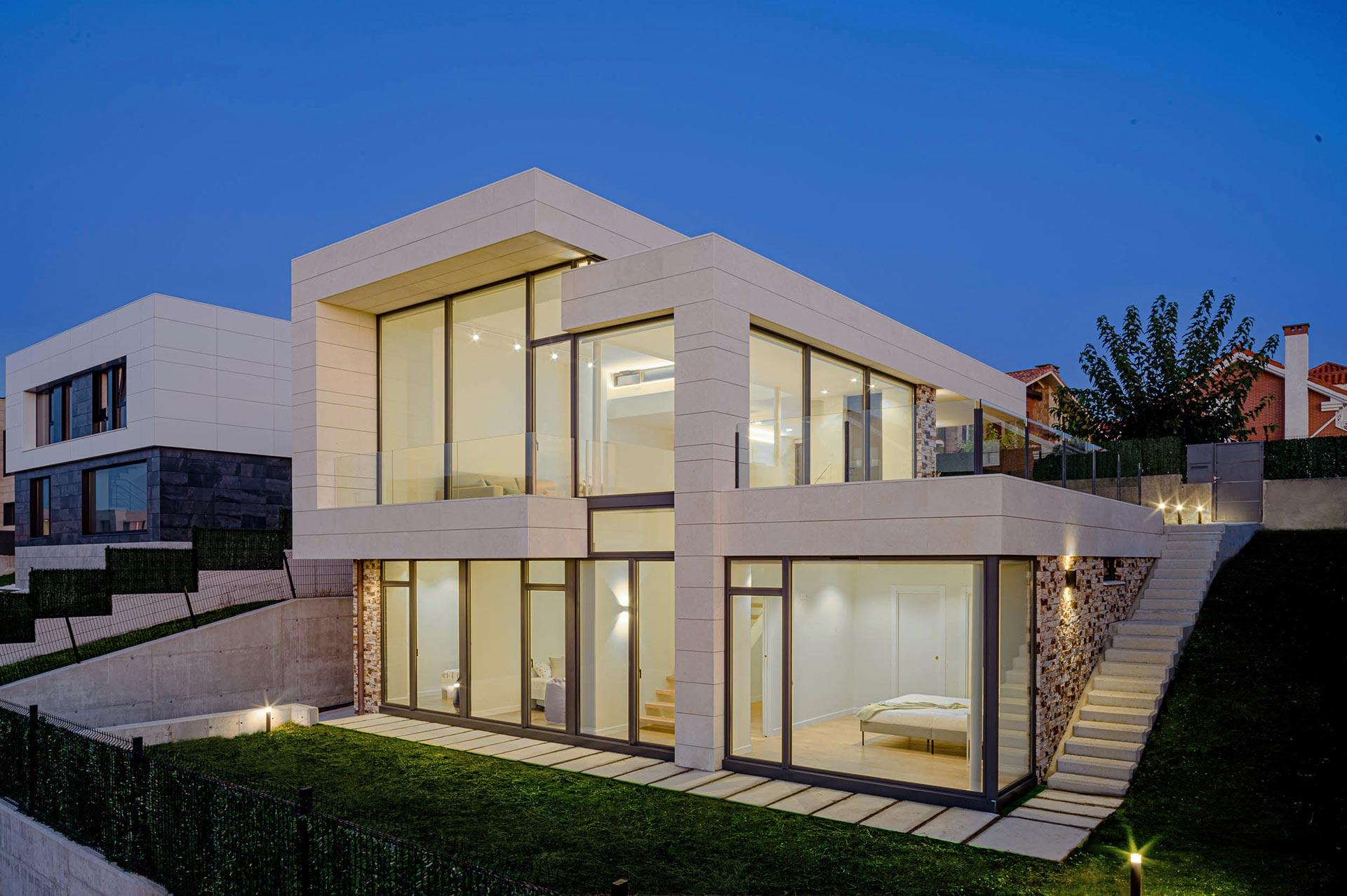 Casa moderna de piedra blanca y grandes cristaleras diseñada por Moah Arquitectos en Liencres. Cantabria