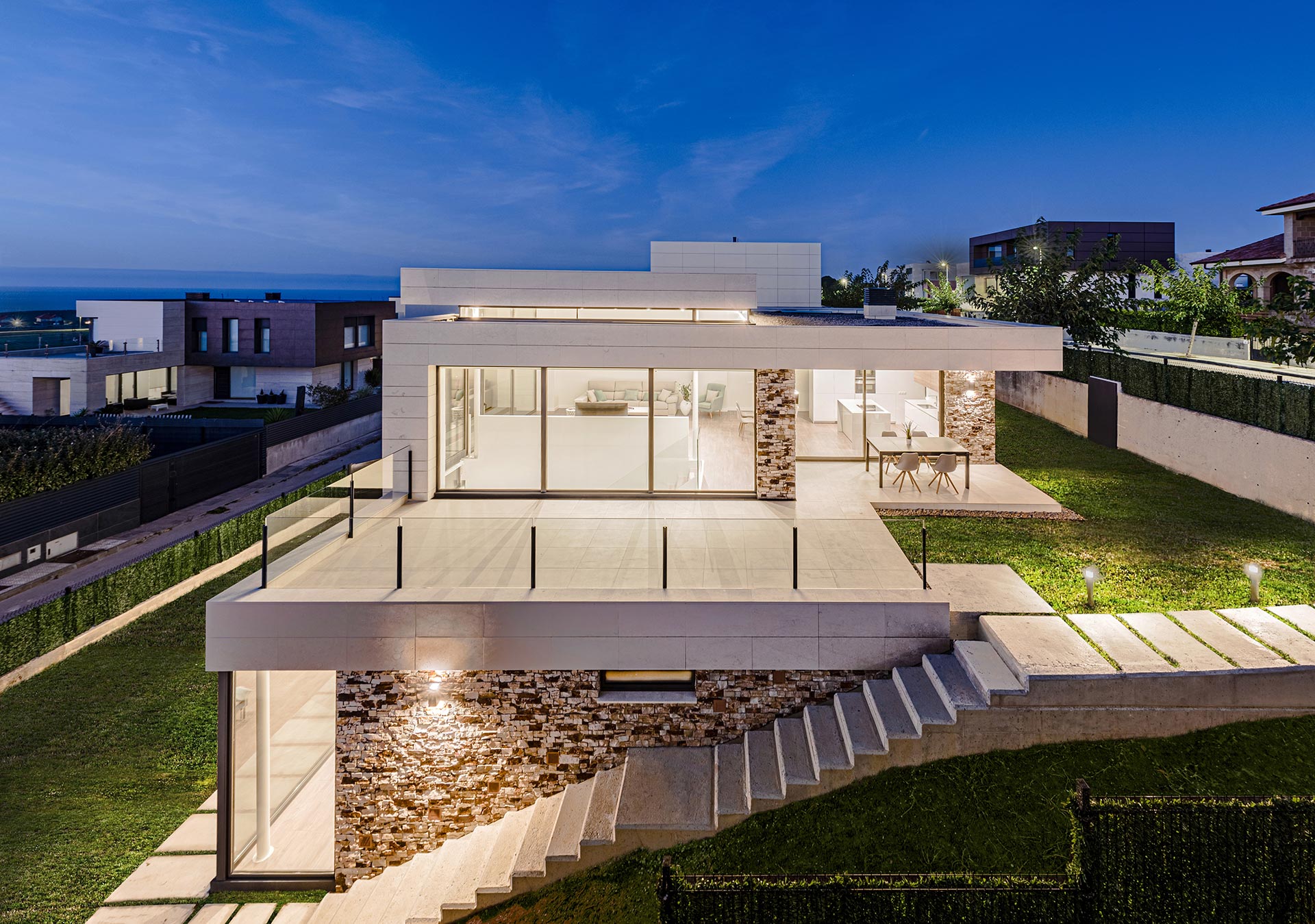 Casa de diseño de piedra blanca y grandes cristaleras diseñada por Moah Arquitectos en Liencres. Cantabria