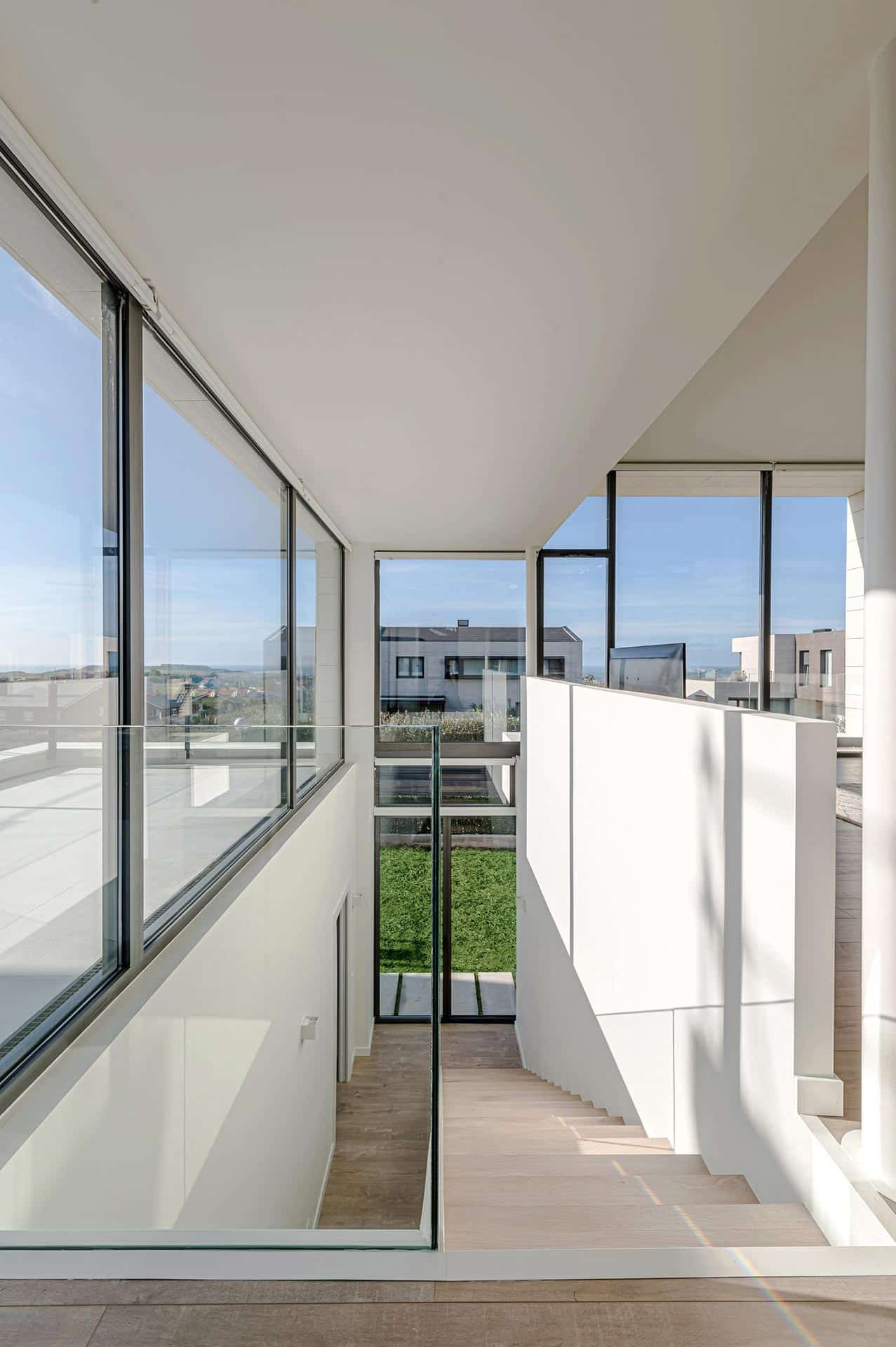 Escalera en doble altura de casa moderna diseñada por Moah Arquitectos en Piélagos. Cantabria