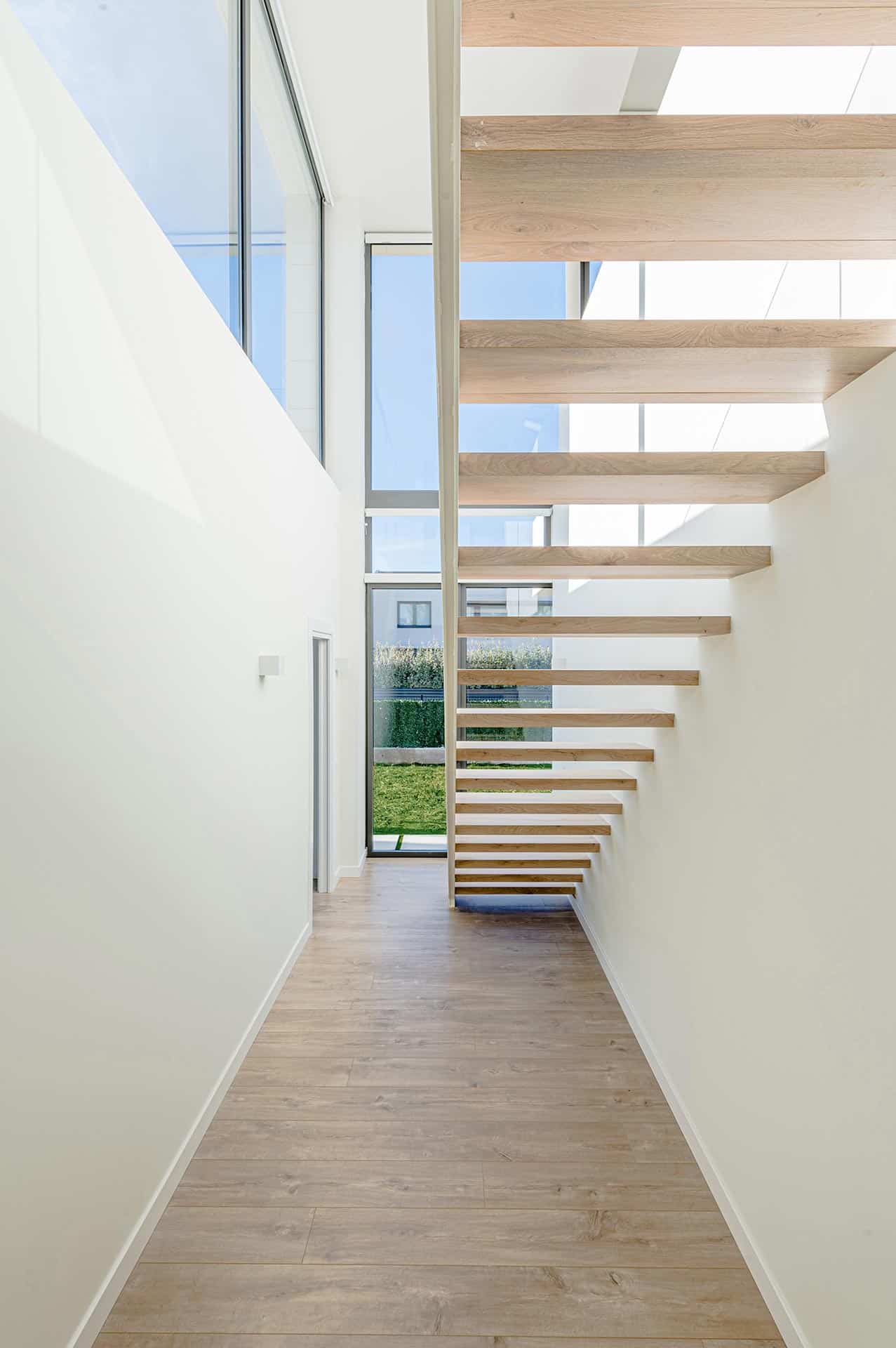 Escalera de madera ligera en vivienda moderna diseñada por Moah Arquitectos en Piélagos. Cantabria