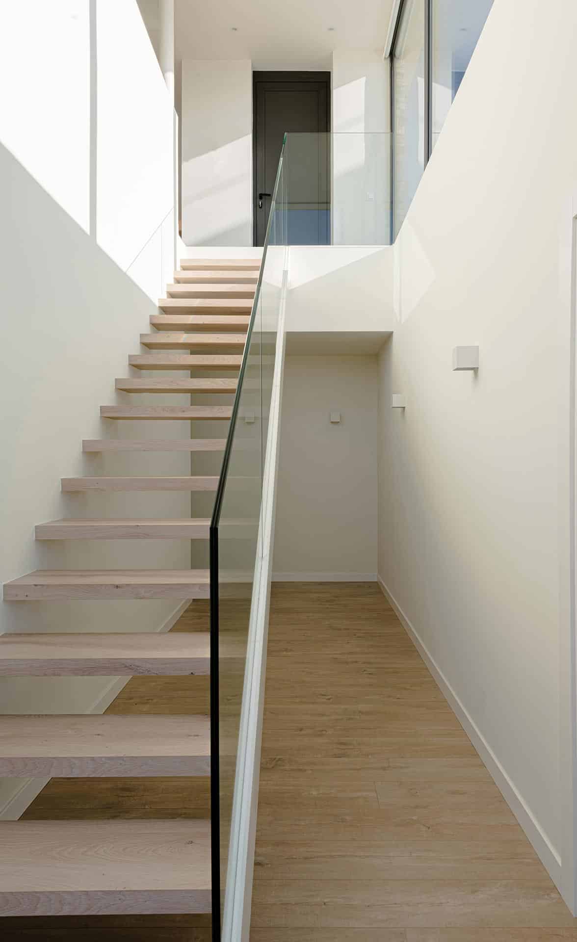Escalera en doble altura en casa de diseño diseñada por Moah Arquitectos en Liencres. Cantabria