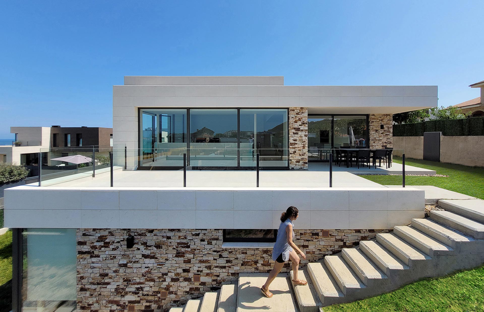 White stone house with exterior stairs designed by Moah Architects in Liencres. Cantabria