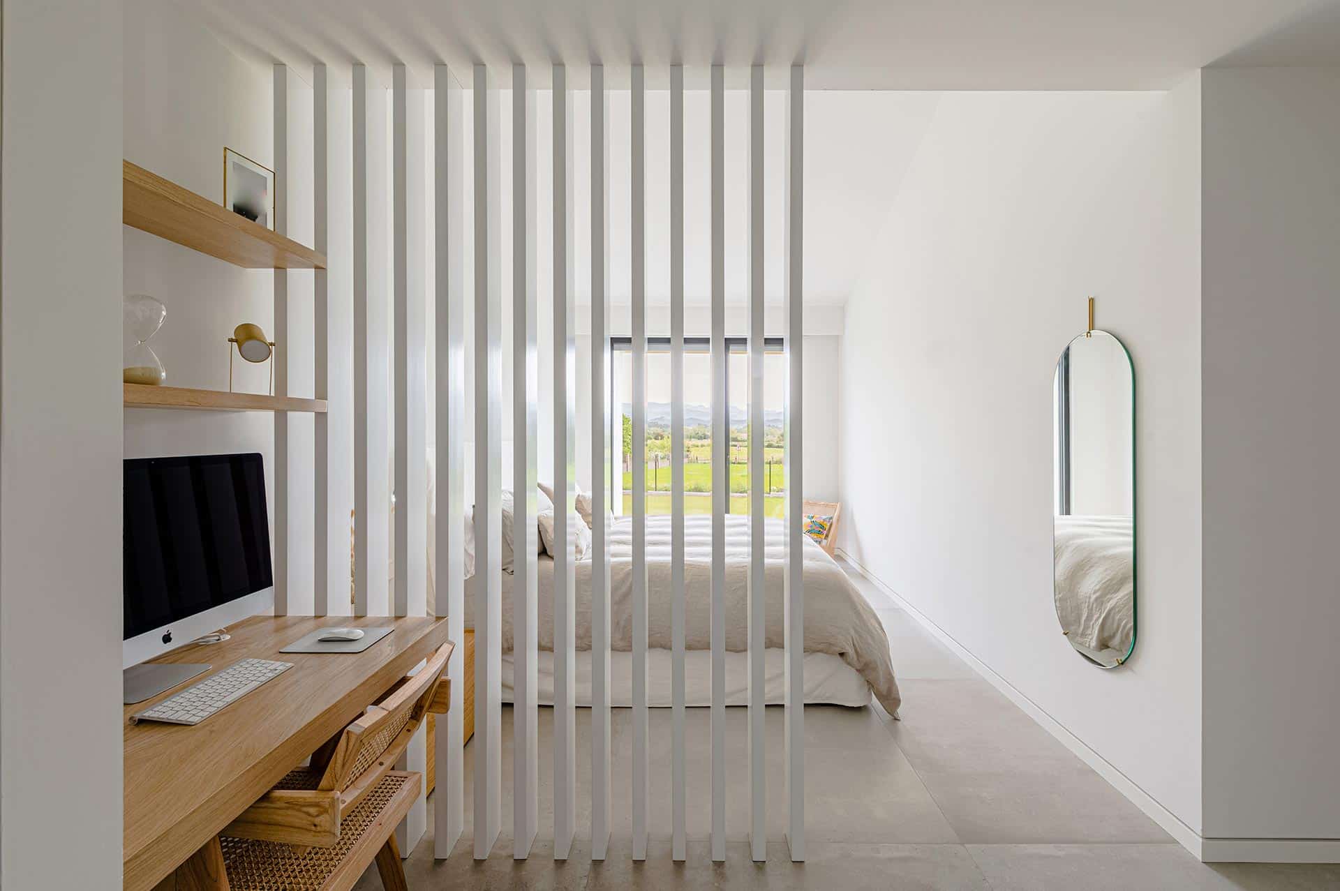 Diseño minimalista de dormitorio con lamas de madera diseñado por Moah Arquitectos en Suesa. Cantabria.