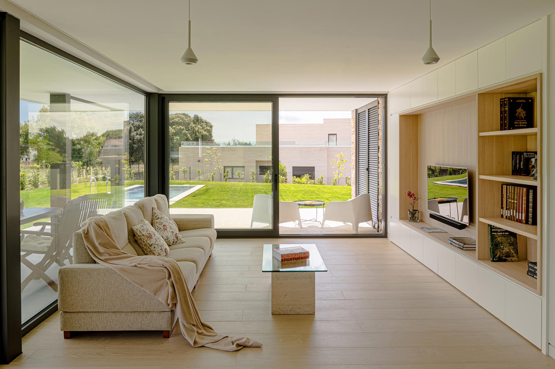 Diseño interior de salón de casa moderna con grandes ventanales diseñada por Moah Arquitectos en Somo. Cantabria