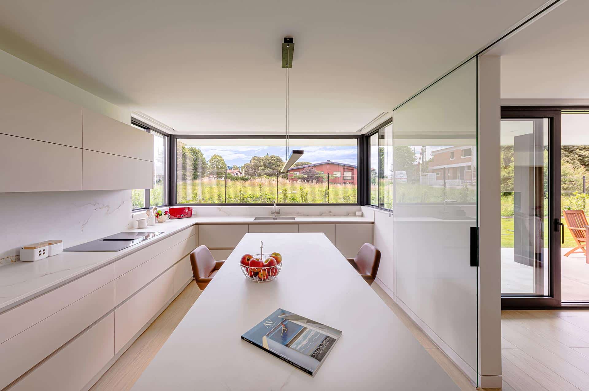 Diseño interior de cocina con isla en casa diseñada por Moah Arquitectos en Somo. Cantabria