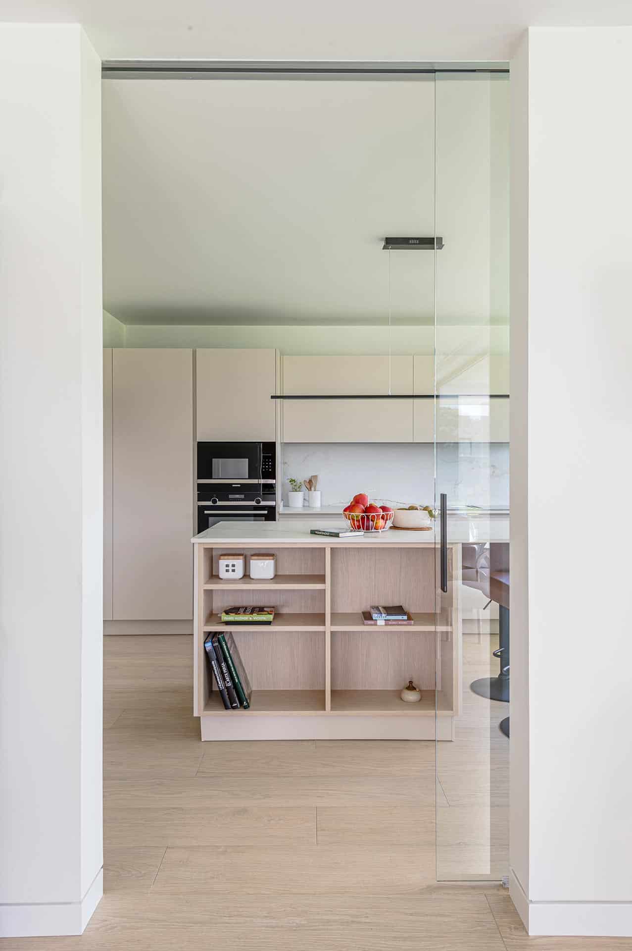Puerta corredera de cristal de separación de cocina en vivienda diseñada por Moah Arquitectos en Somo. Cantabria
