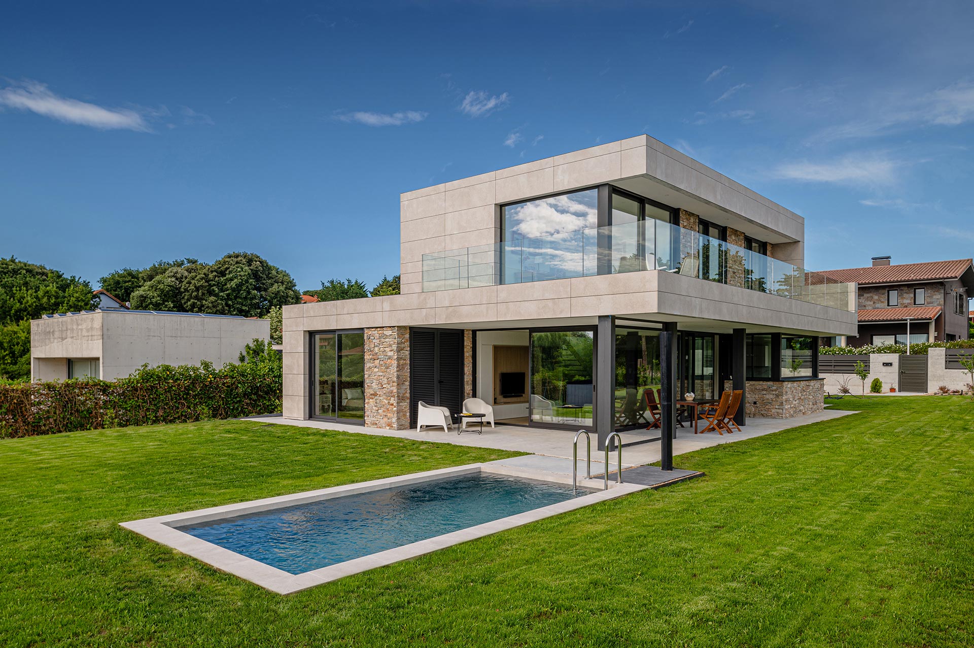 Casa moderna con piscina, porche y grandes cristaleras diseñada por Moah Arquitectos en Somo. Cantabria