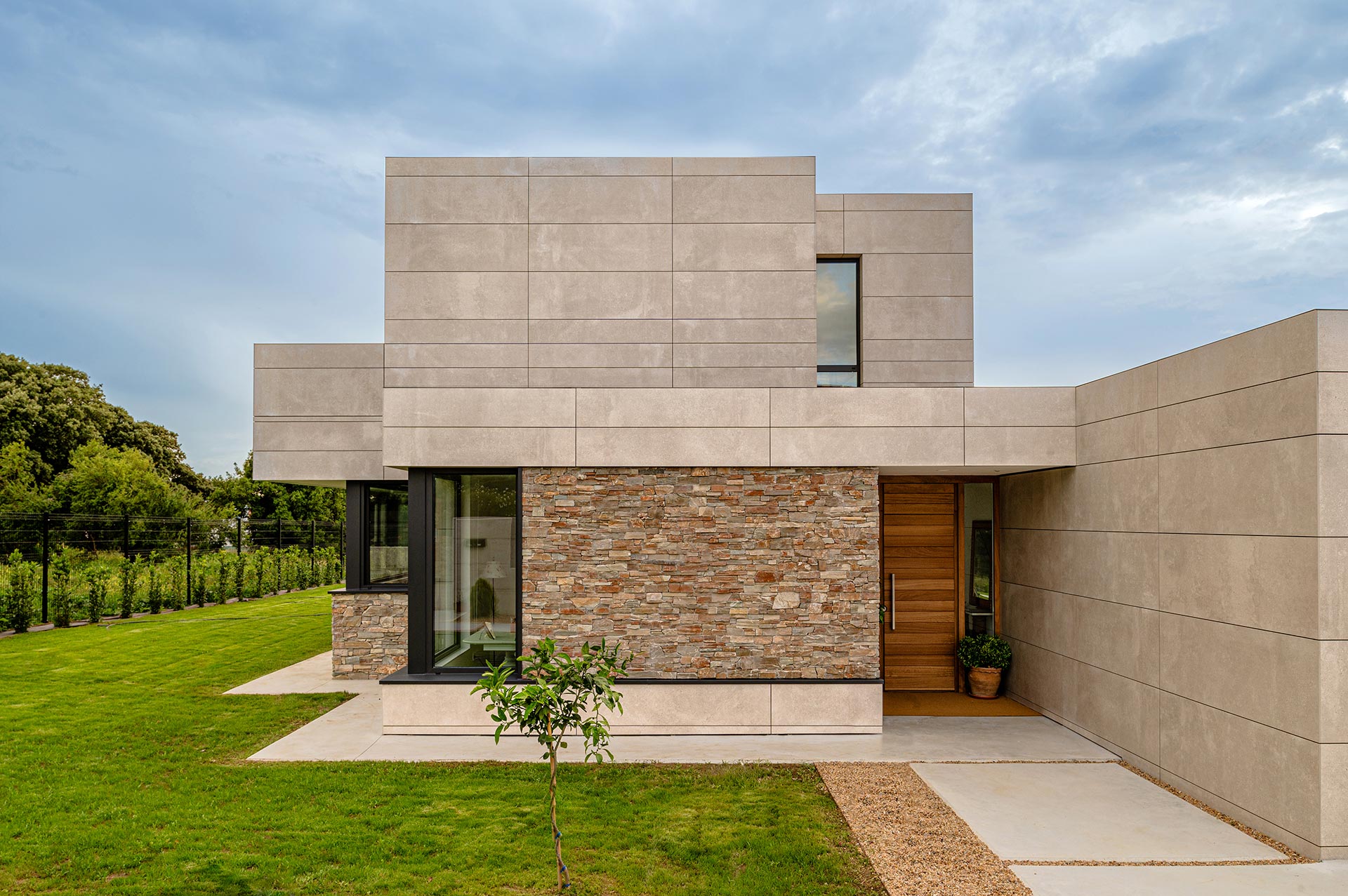 Entrada de casa moderna de fachada ventilada y pidera diseñada por Moah Arquitectos en Somo. Cantabria