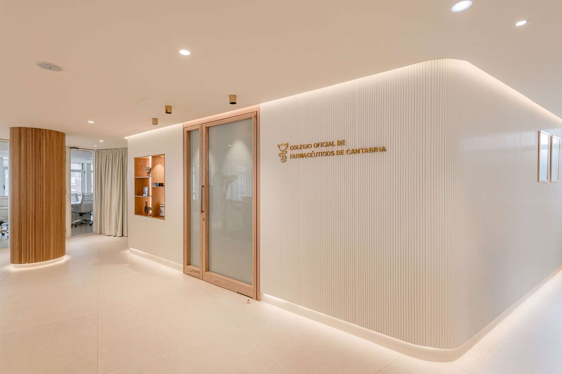 Vestíbulo de entrada con acabados en madera y una estética moderna, diseñada por Moah Arquitectos en Santander.