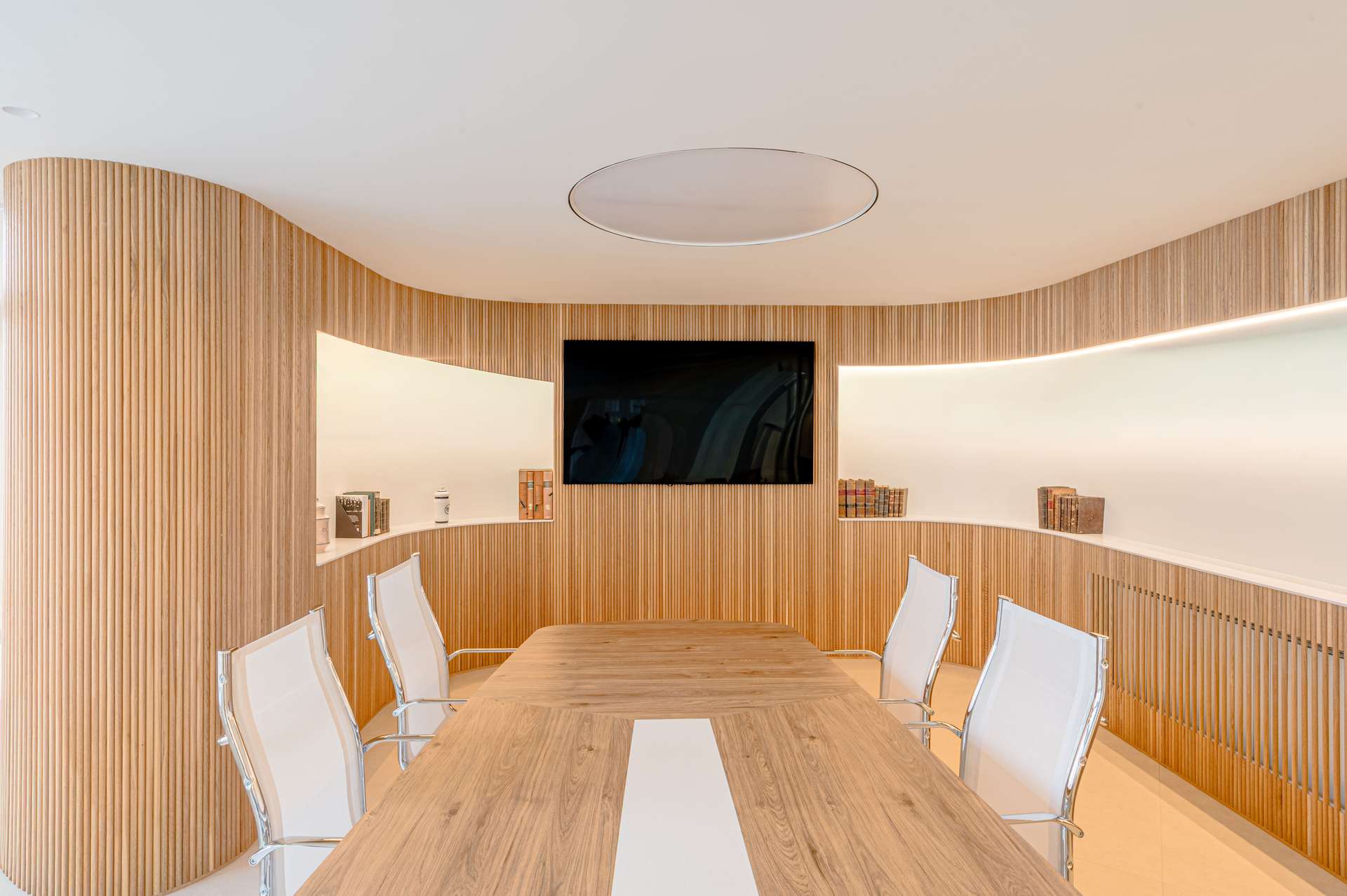 Sala de reuniones con paredes de madera y mesa de madera, diseñada por Moah Arquitectos en Santander.